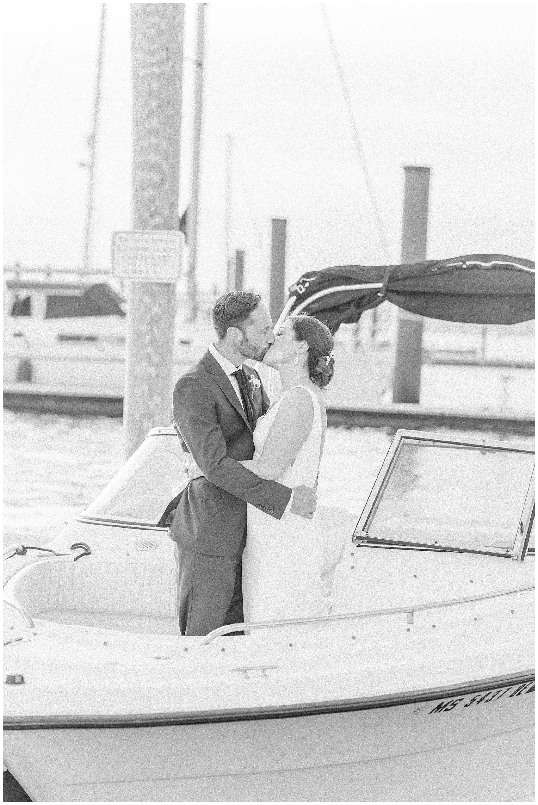 newlyweds kiss on their boat in the Bristol Harbor RI