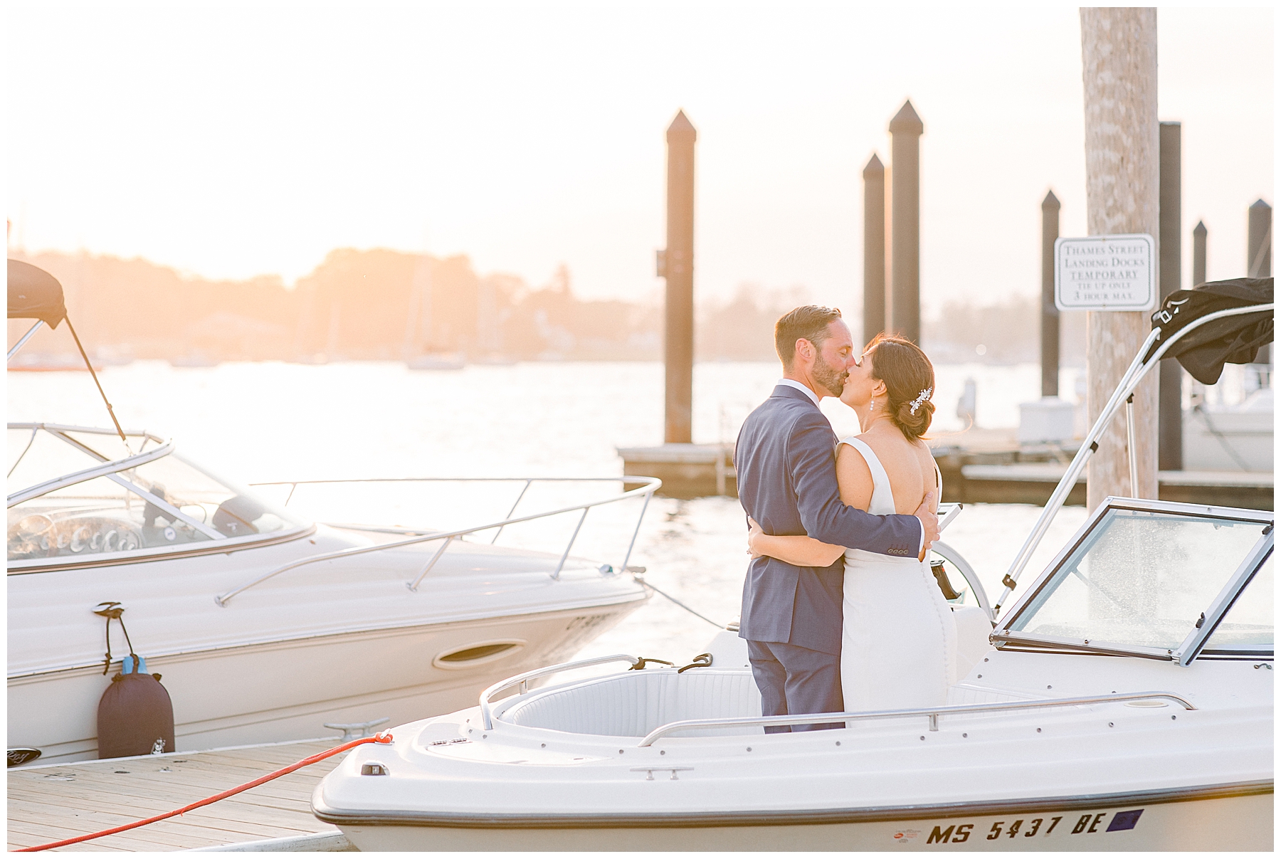 newlyweds kiss at sunset on a boat in the RI harbor captured by Stephanie Berenson Photography