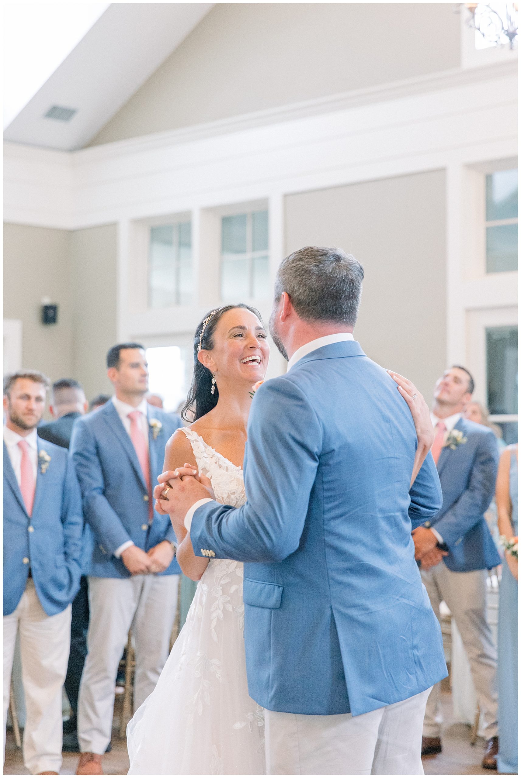 husband and wife laugh as the dance together at wedding reception