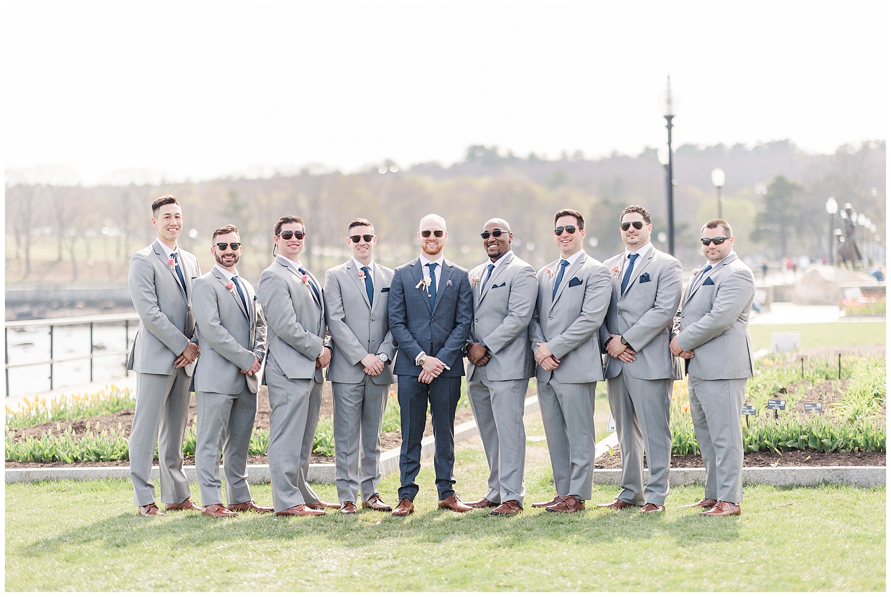 Groomsmen stand with groom wearing matching black sunglasses