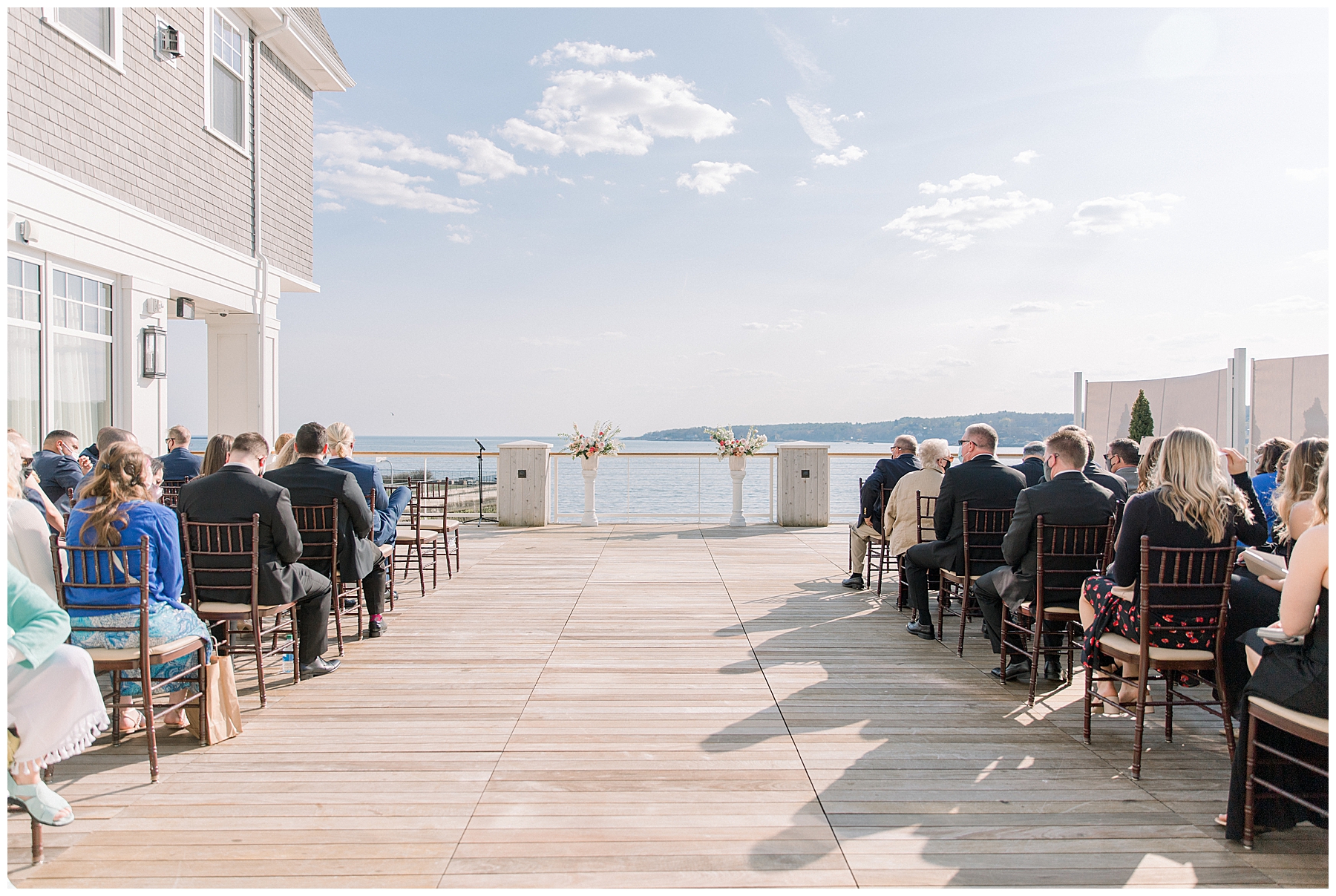 Guests wait for Beauport Hotel wedding ceremony to start overlooking the ocean in Gloucester MA