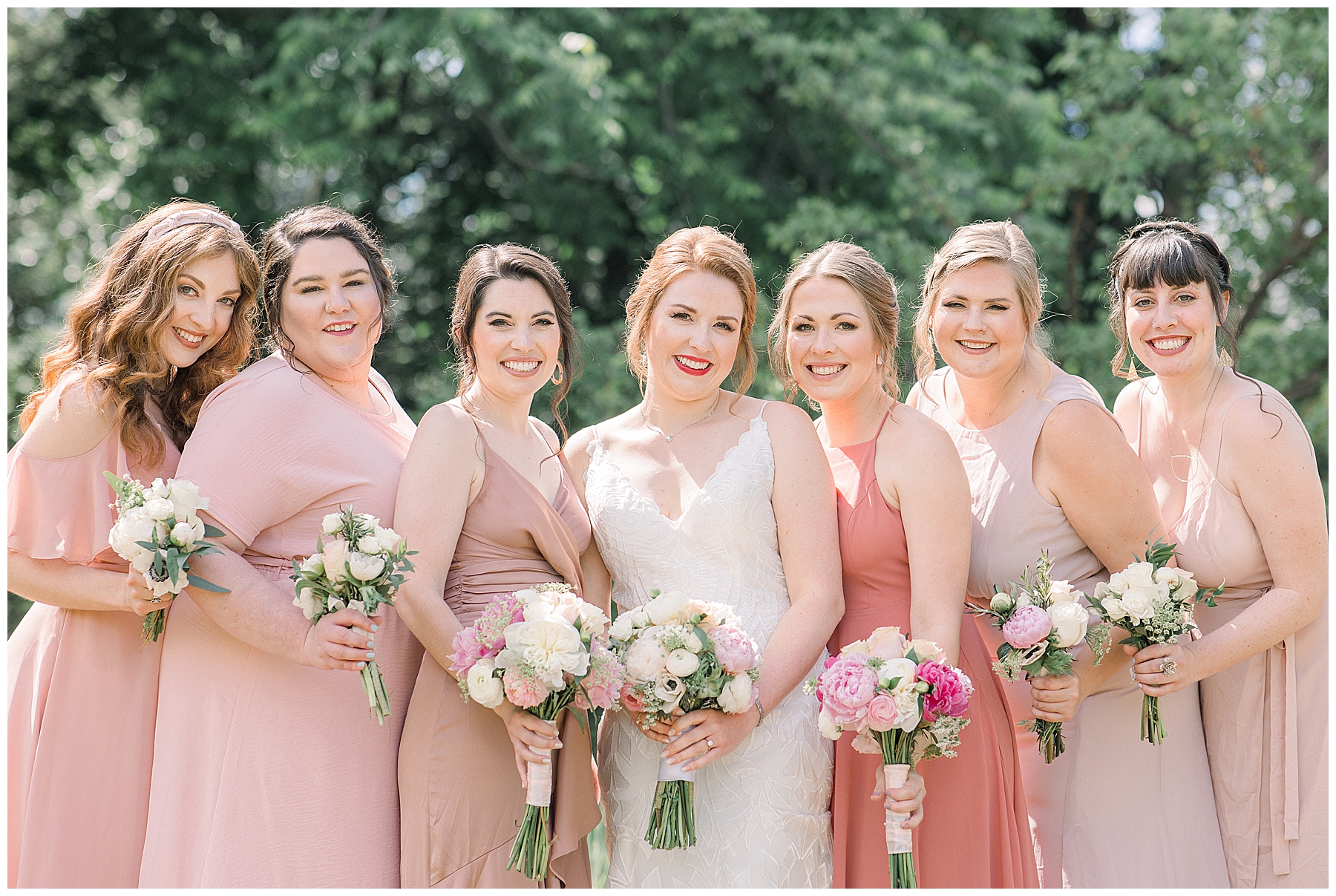 bridesmaids in blush dresses holding flower bouquets