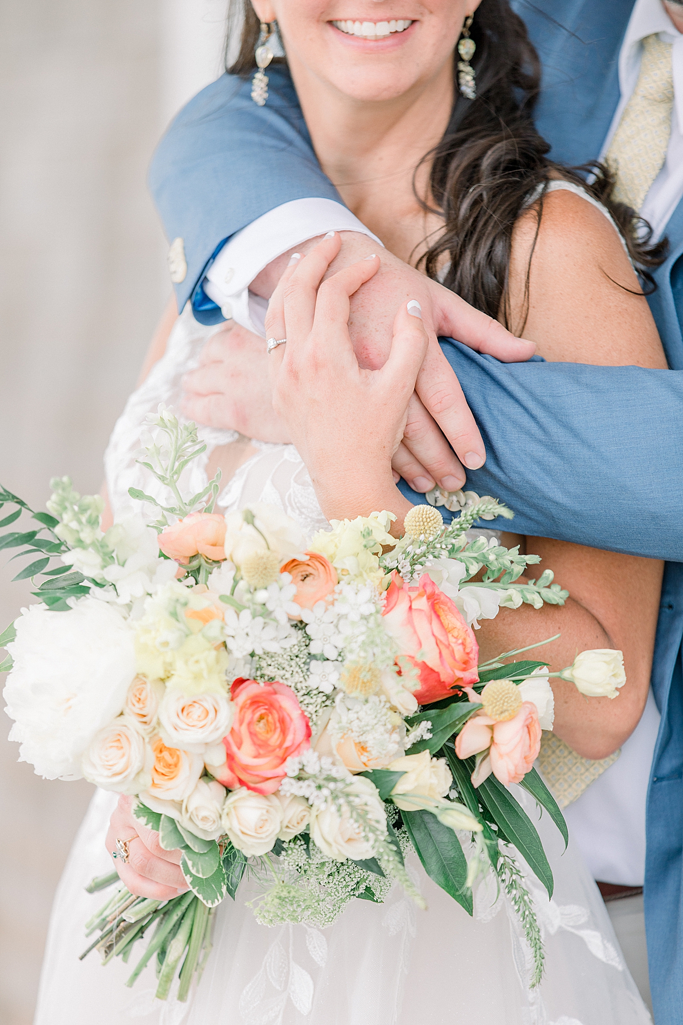 newlyweds hug showing off bride's bouquet