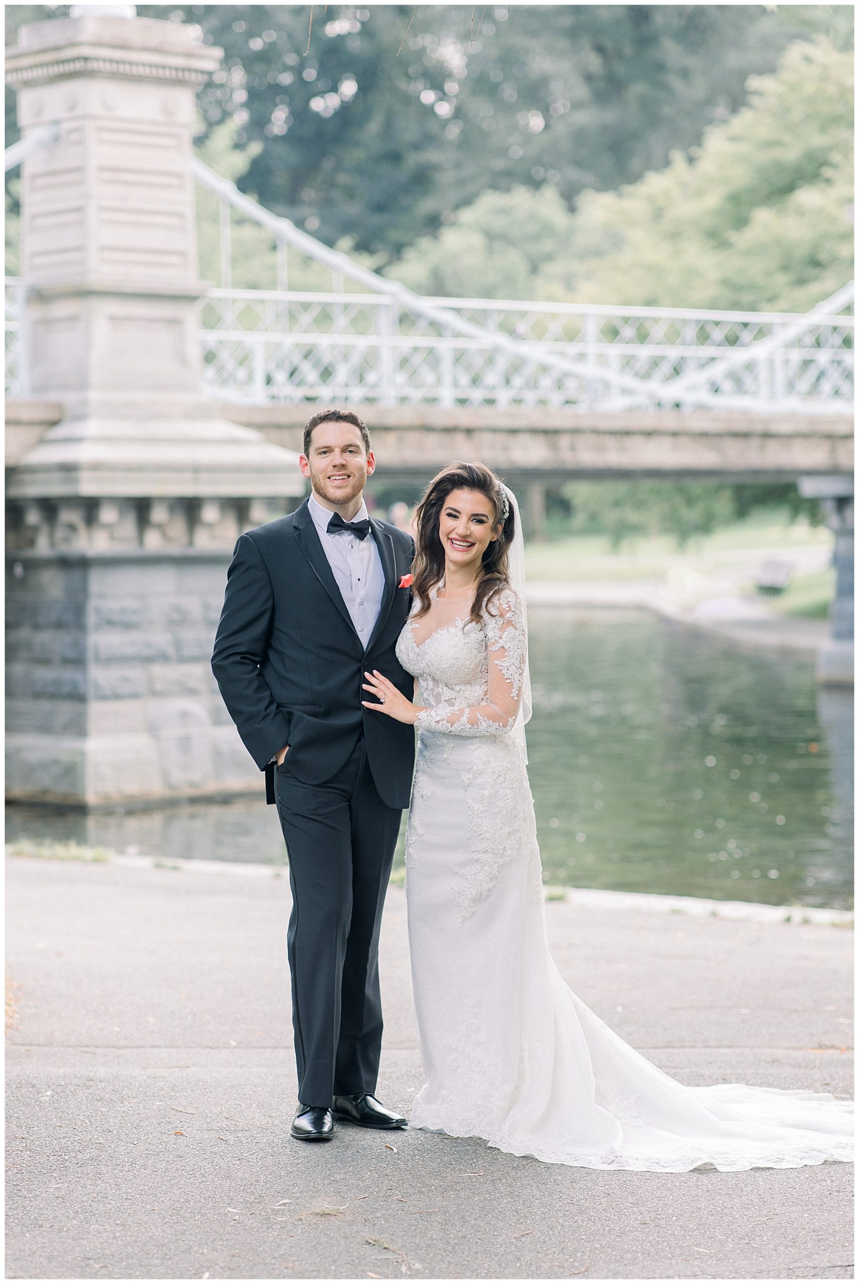 bride + groom outside wedding venue with white bridge in background