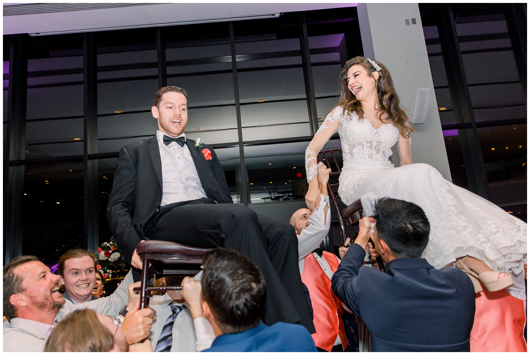 newlyweds go for a ride as guests lift them up and celebrate their wedding day