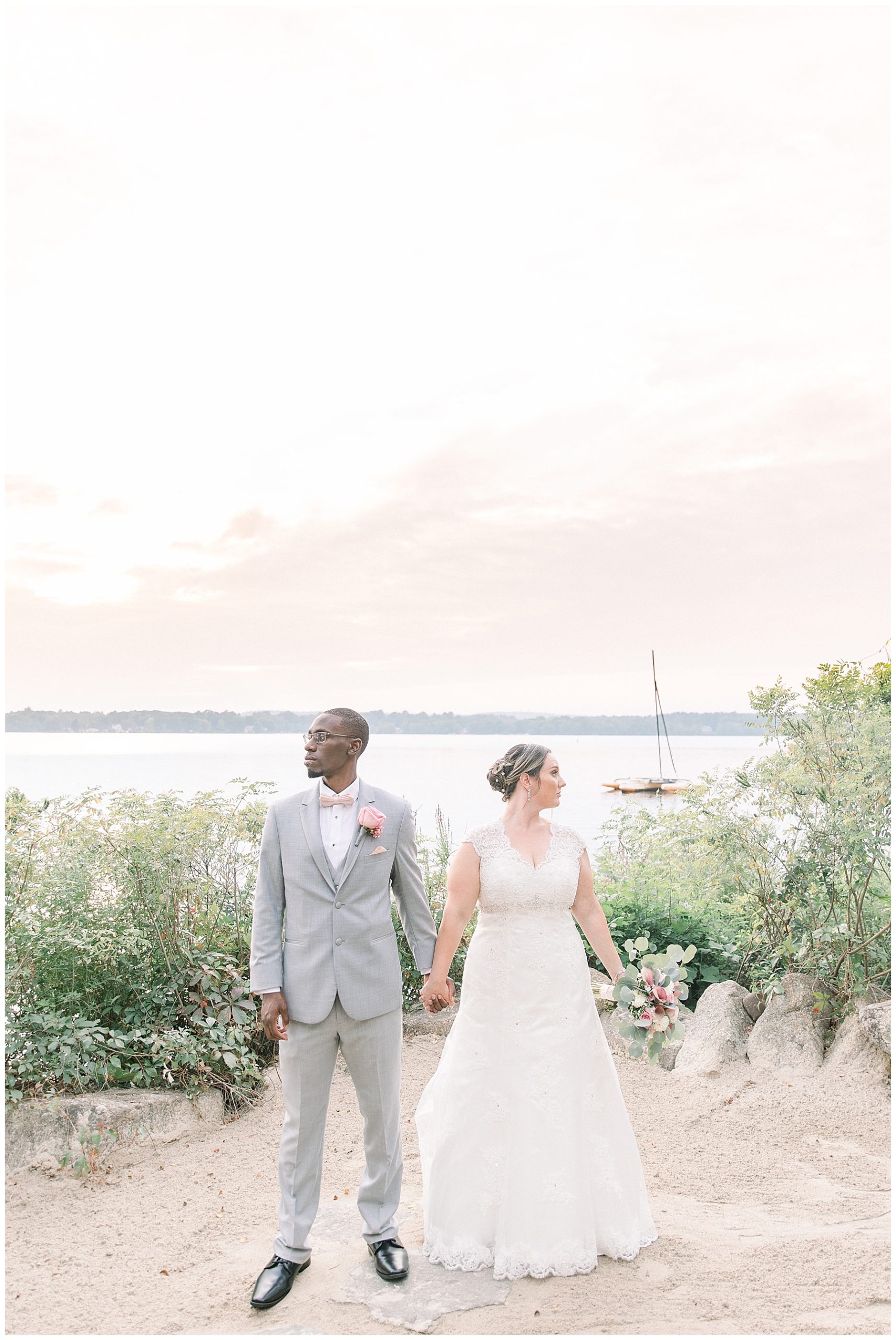 bride and groom look opposite directions by the water