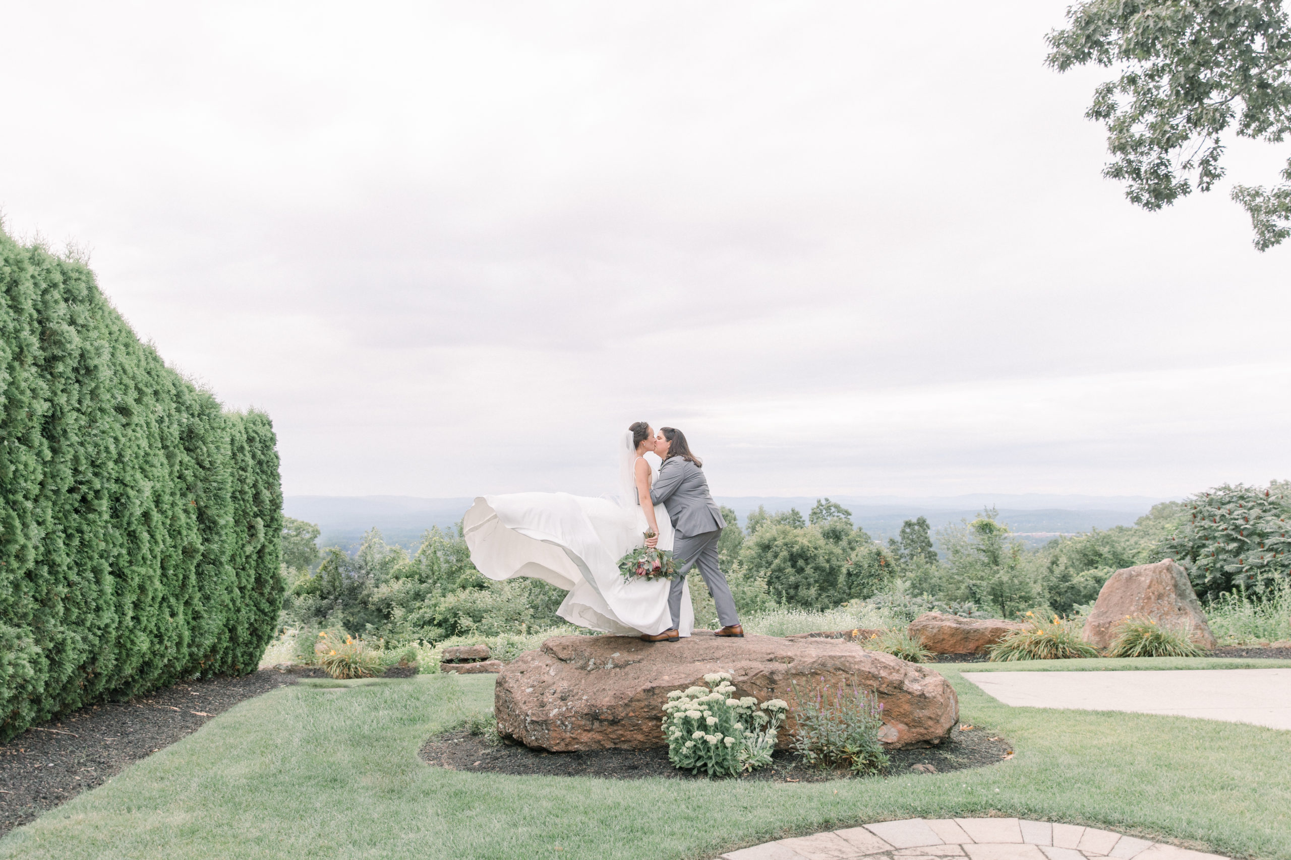 newlyweds kiss on rock at MA wedding