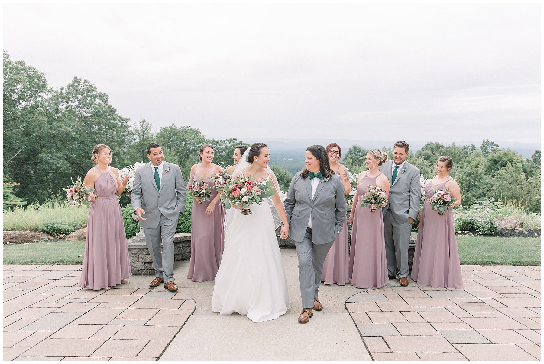 couple hold hands with bridal party in background