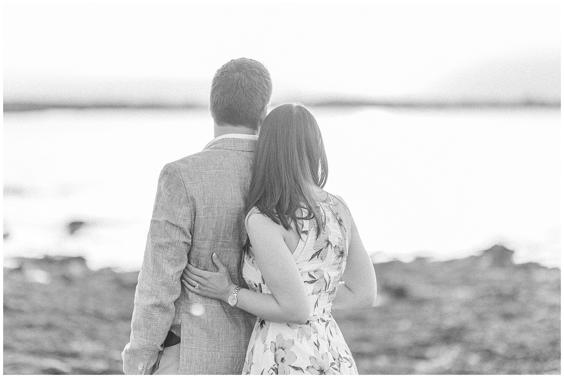 black and white photo of couple looking out over the water