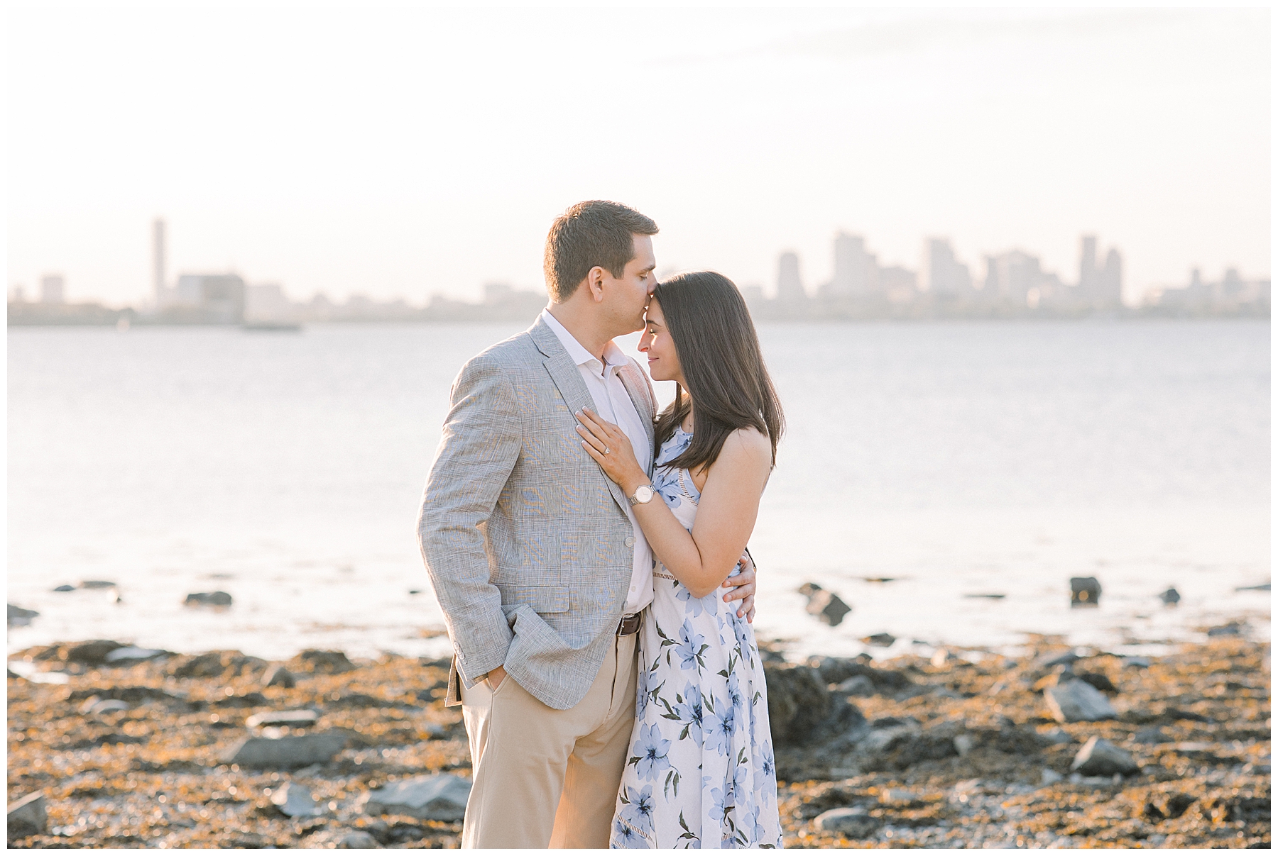 couple during engagement session in Boston MA with the skyline in background