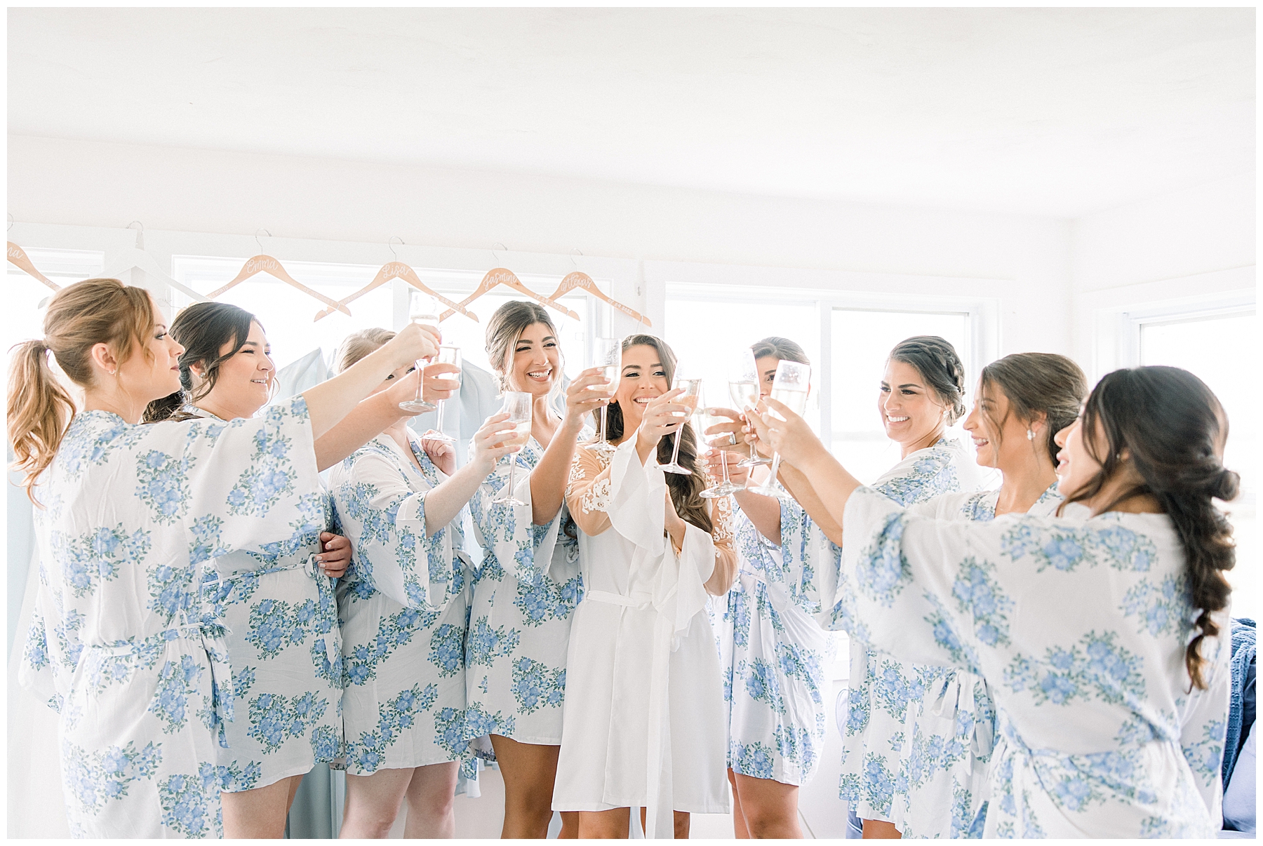 bride and bridesmaids toast and drink champagne as they get ready for MA wedding