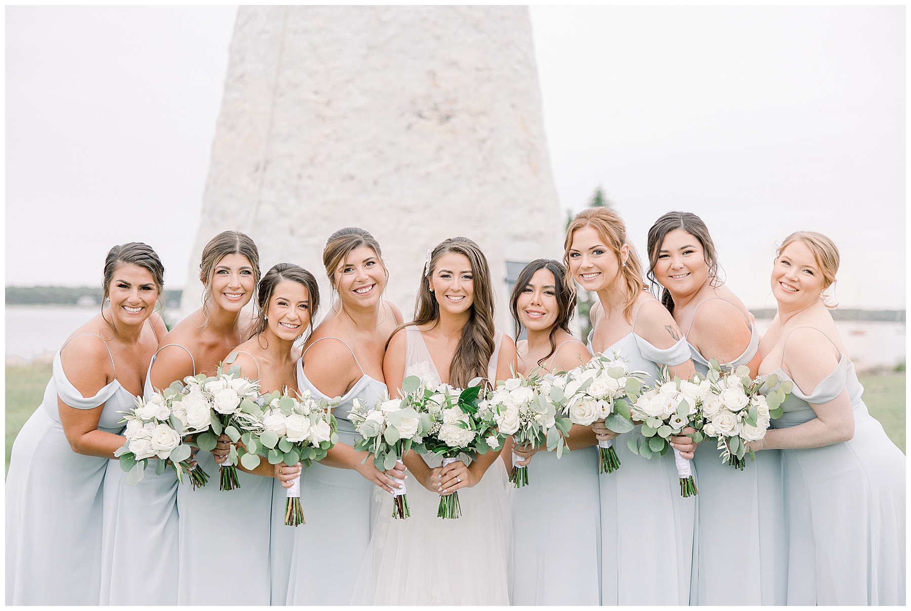 Bridesmaids stand around bride