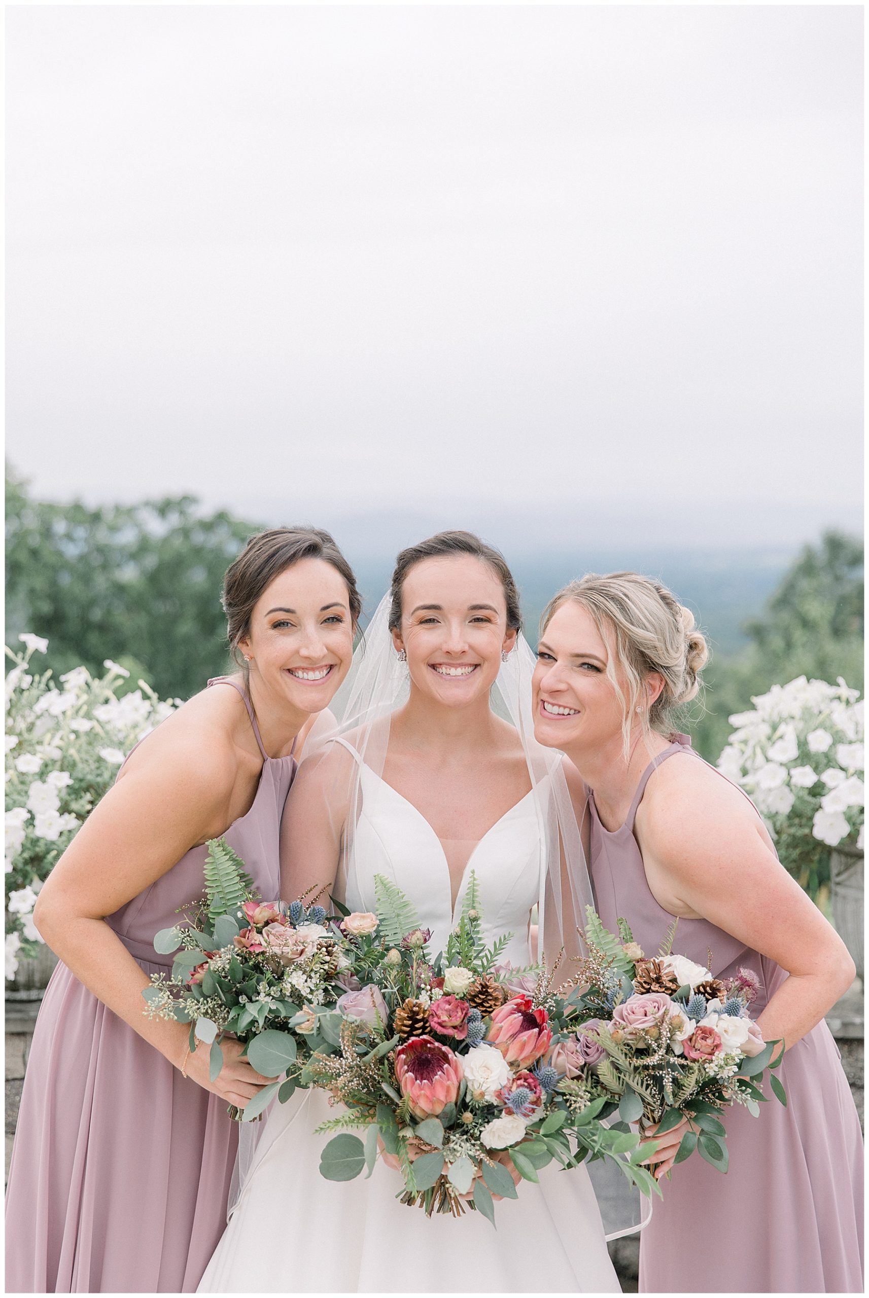 bridesmaids pose with bride during portraits in MA