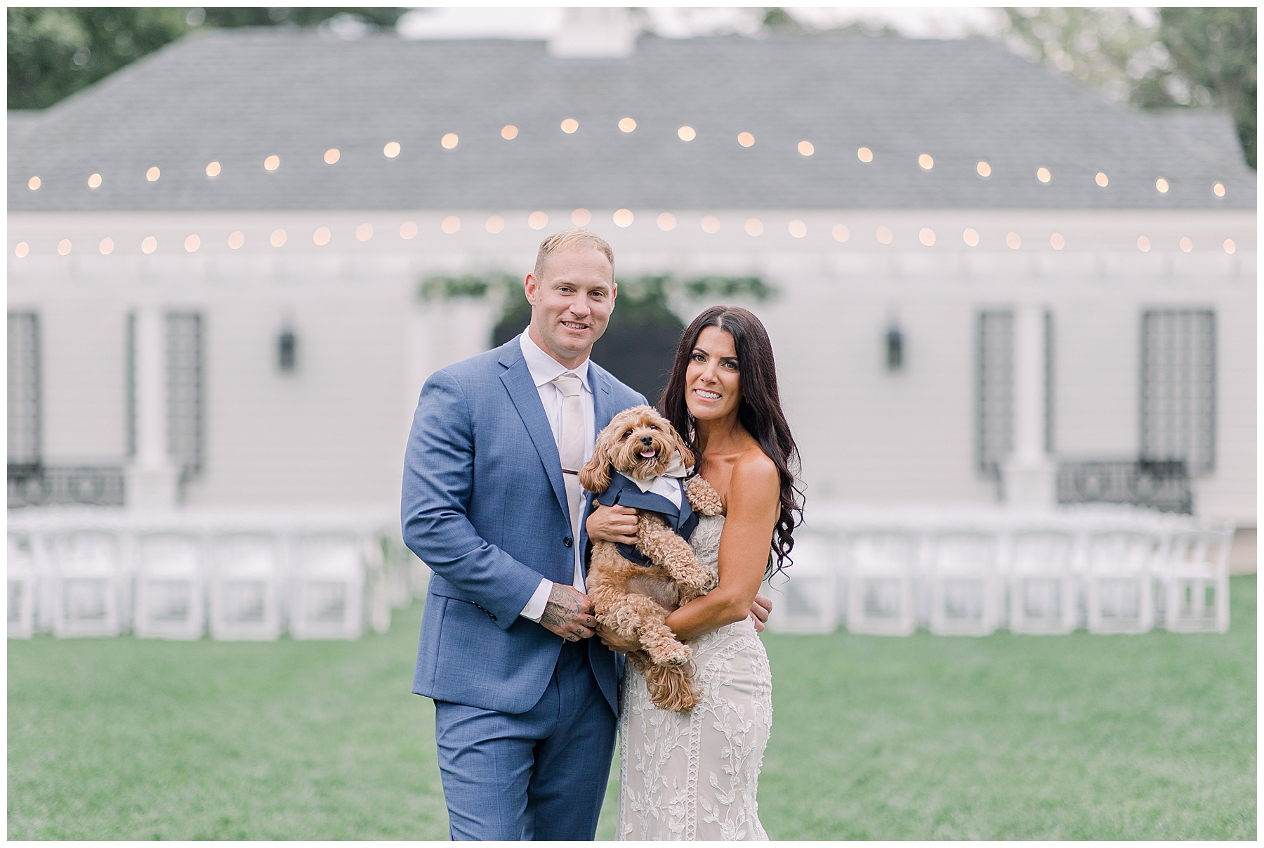 newlyweds hold their ring bearer and dog after wedding ceremony