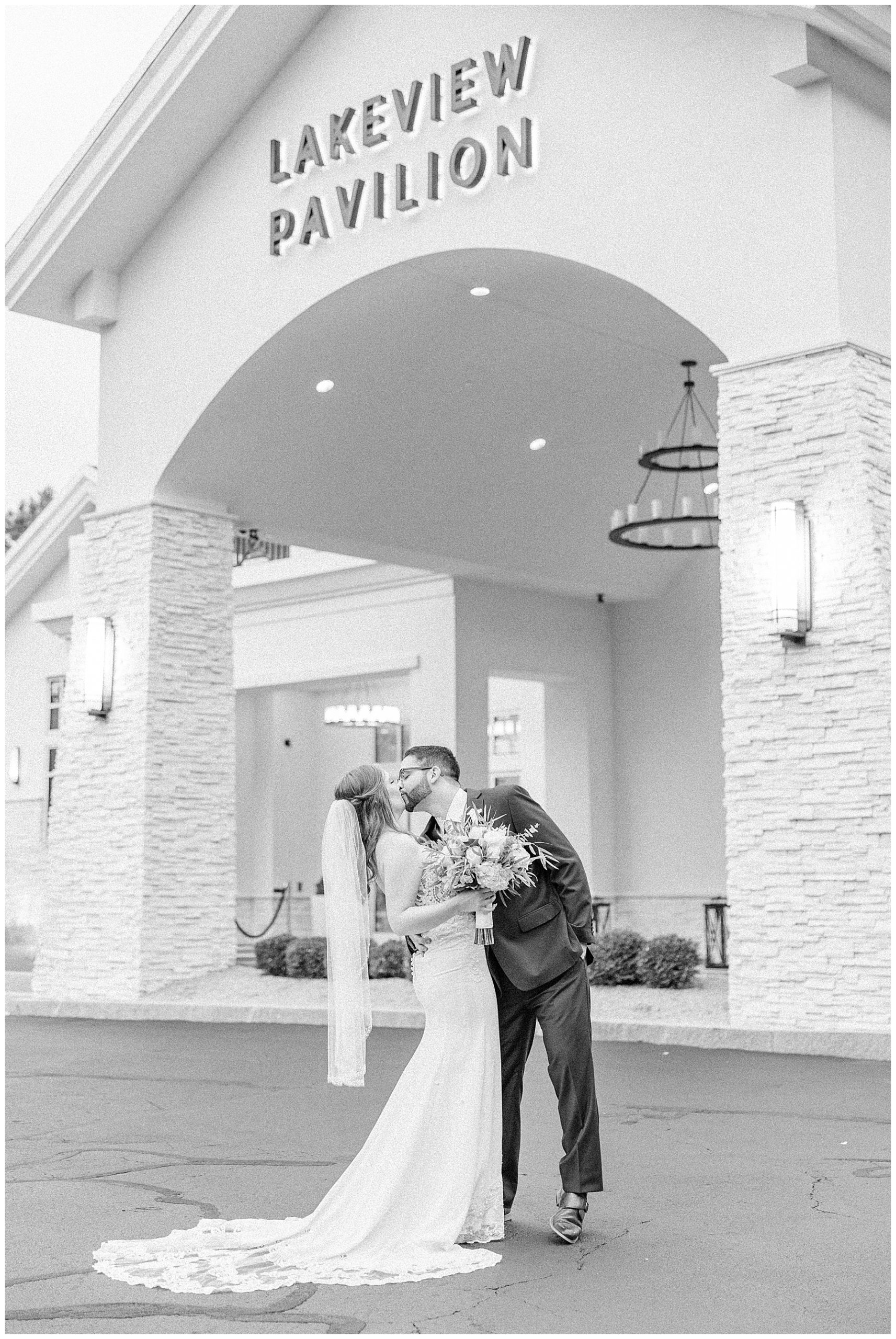 bride and groom kiss outside the Lakeview Pavilion in MA