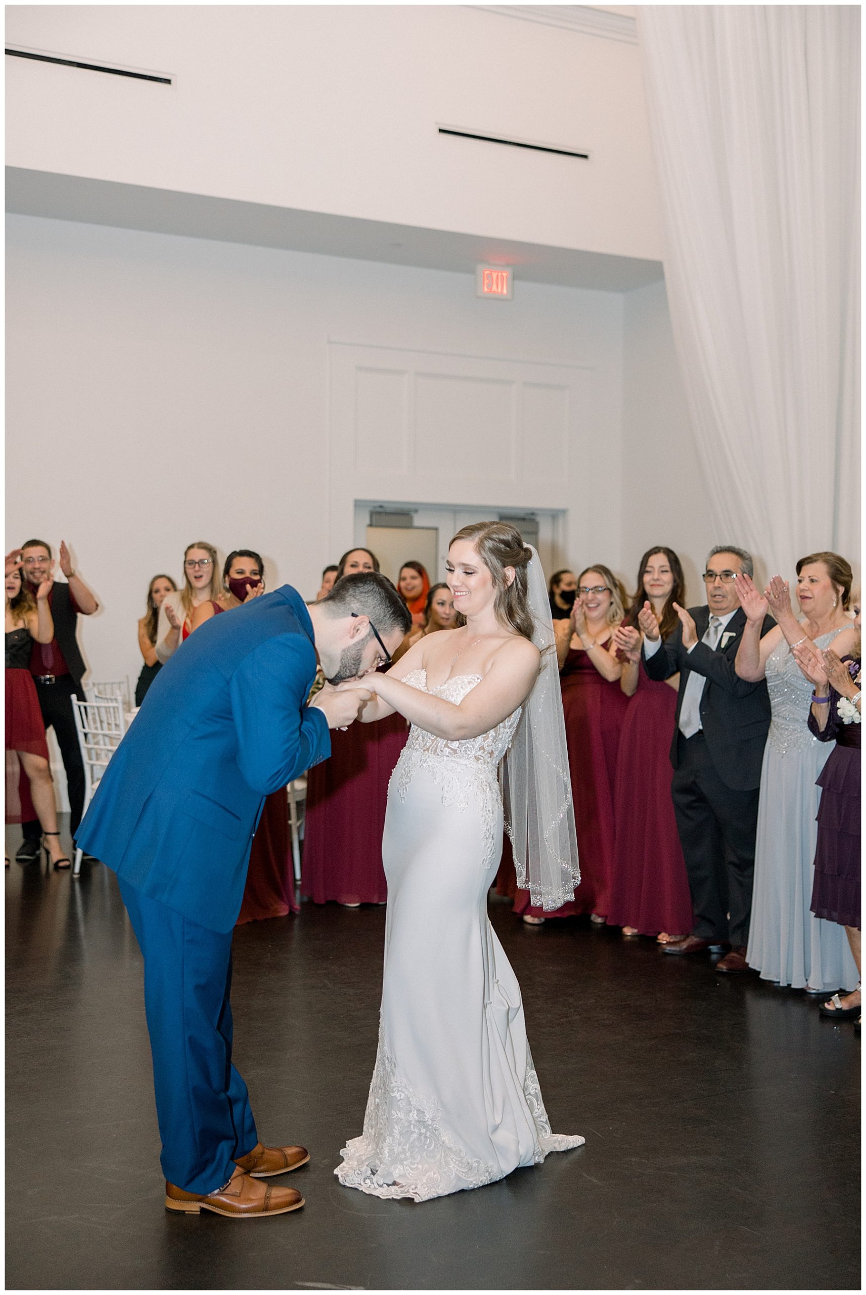 groom kisses bride's hand at MA wedding reception
