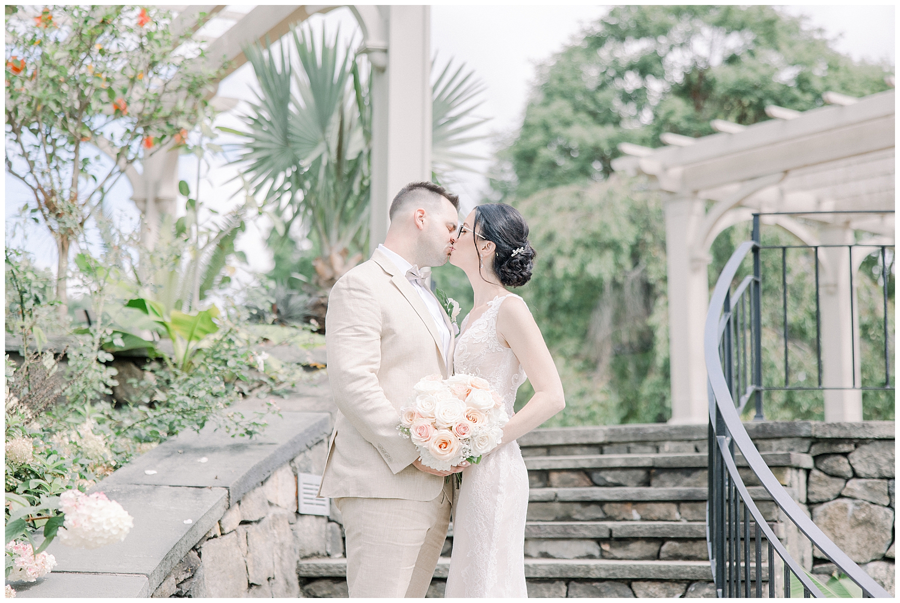 couple kiss on staircase at Tower Hill Botanic Garden Wedding