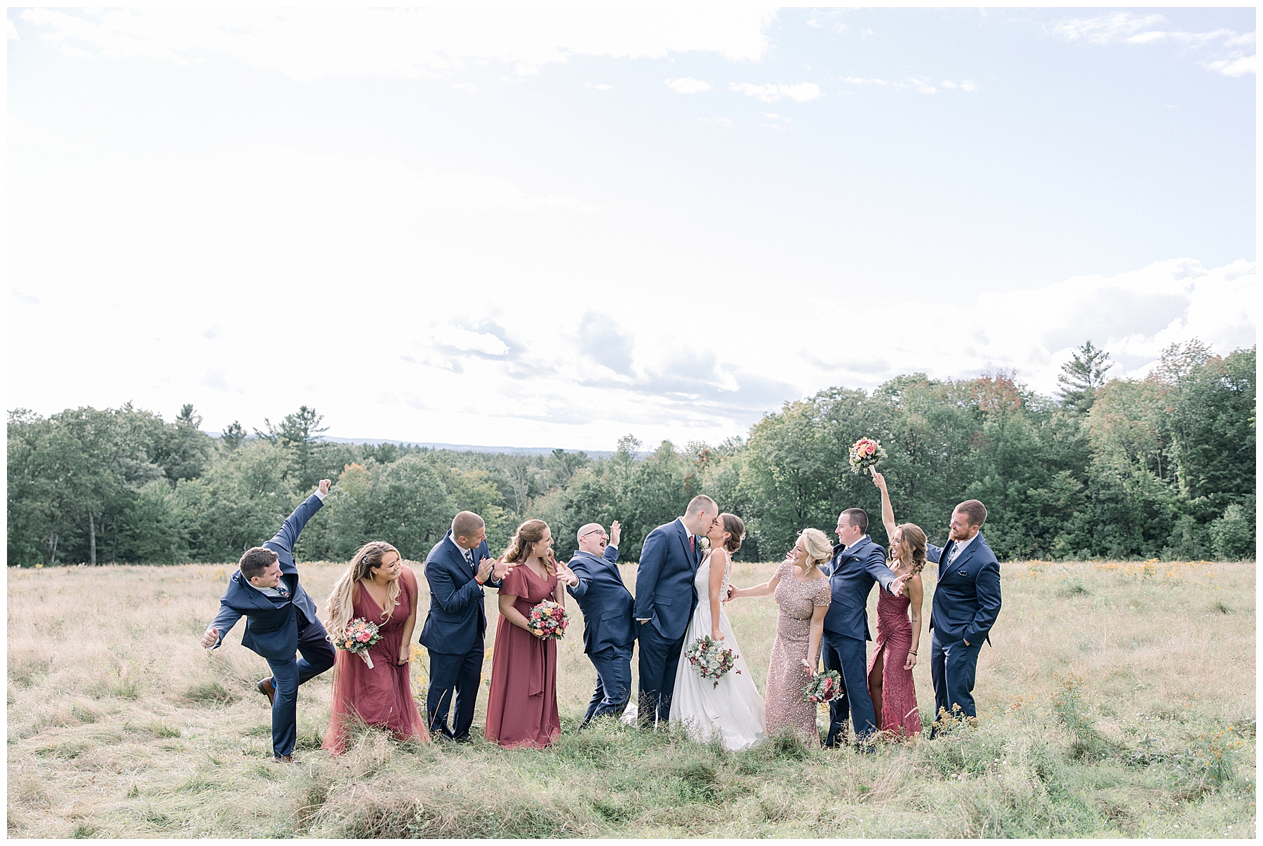 bridal party celebrates bride and groom kissing 