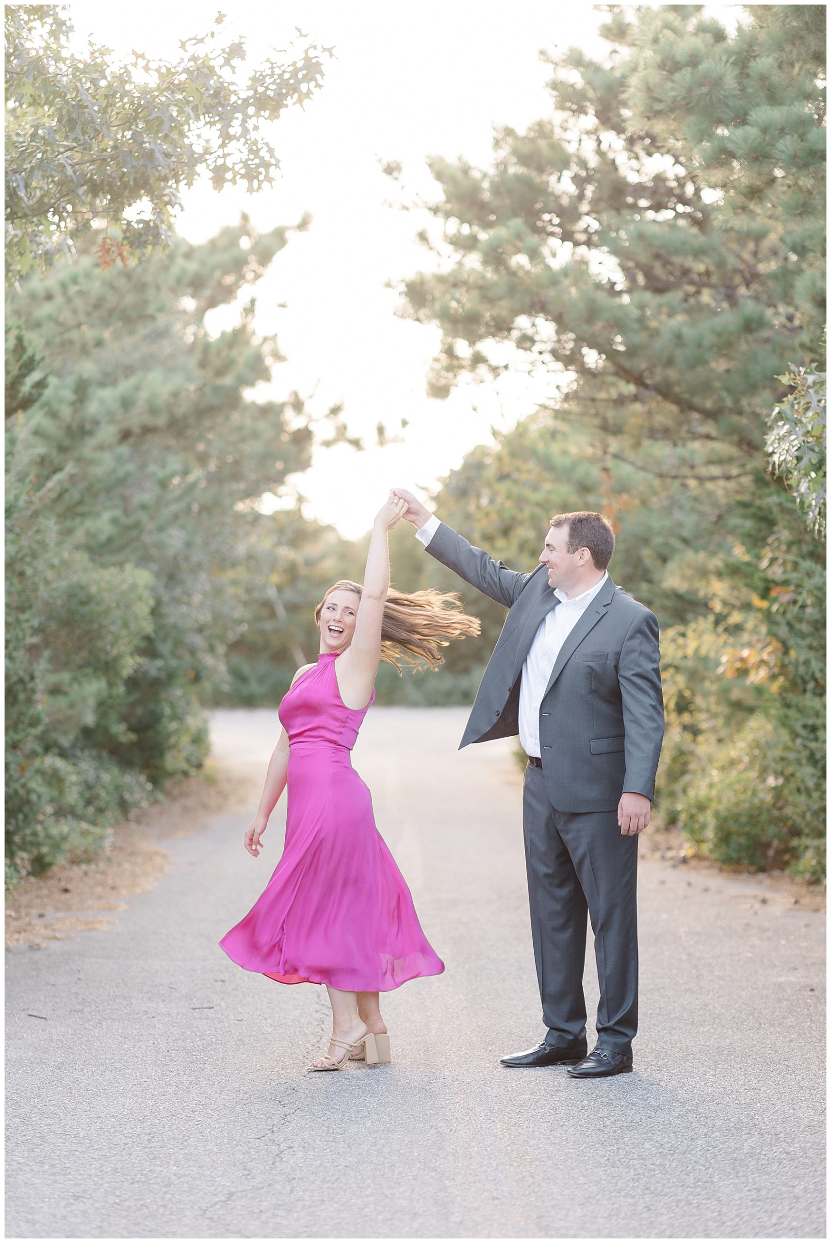 man twirls fiance around in pink dress 