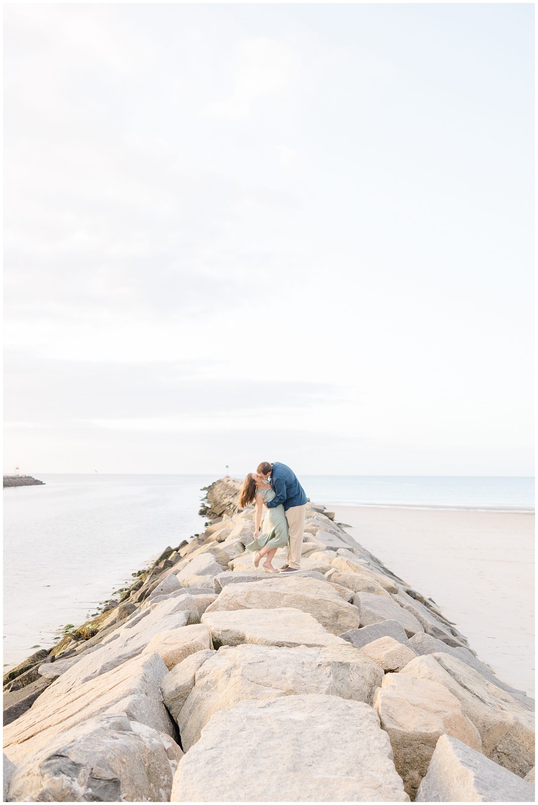 couple kiss on the rocks at beach in MA 