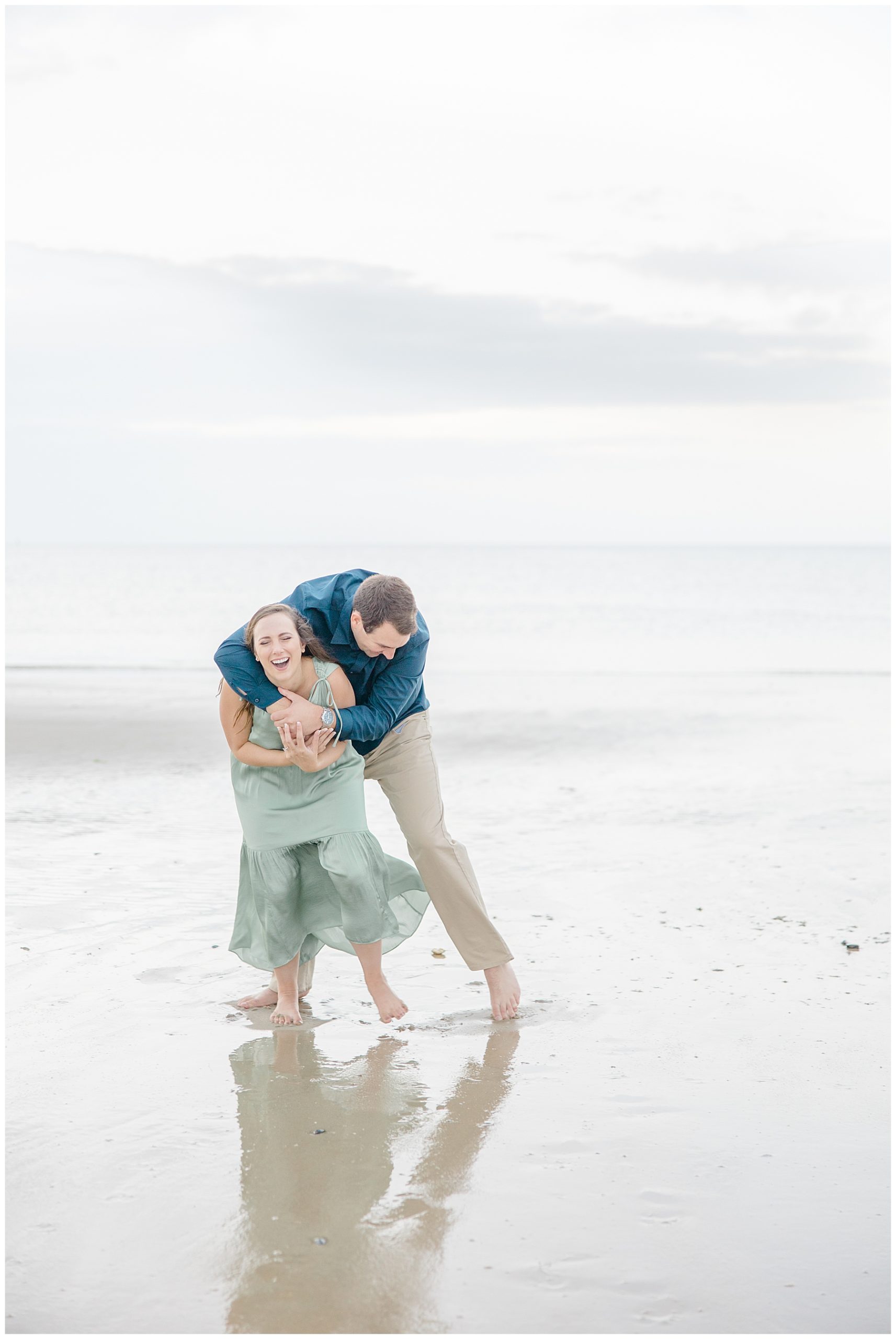 couple have fun at beach in Cape Cod during engagement photos 