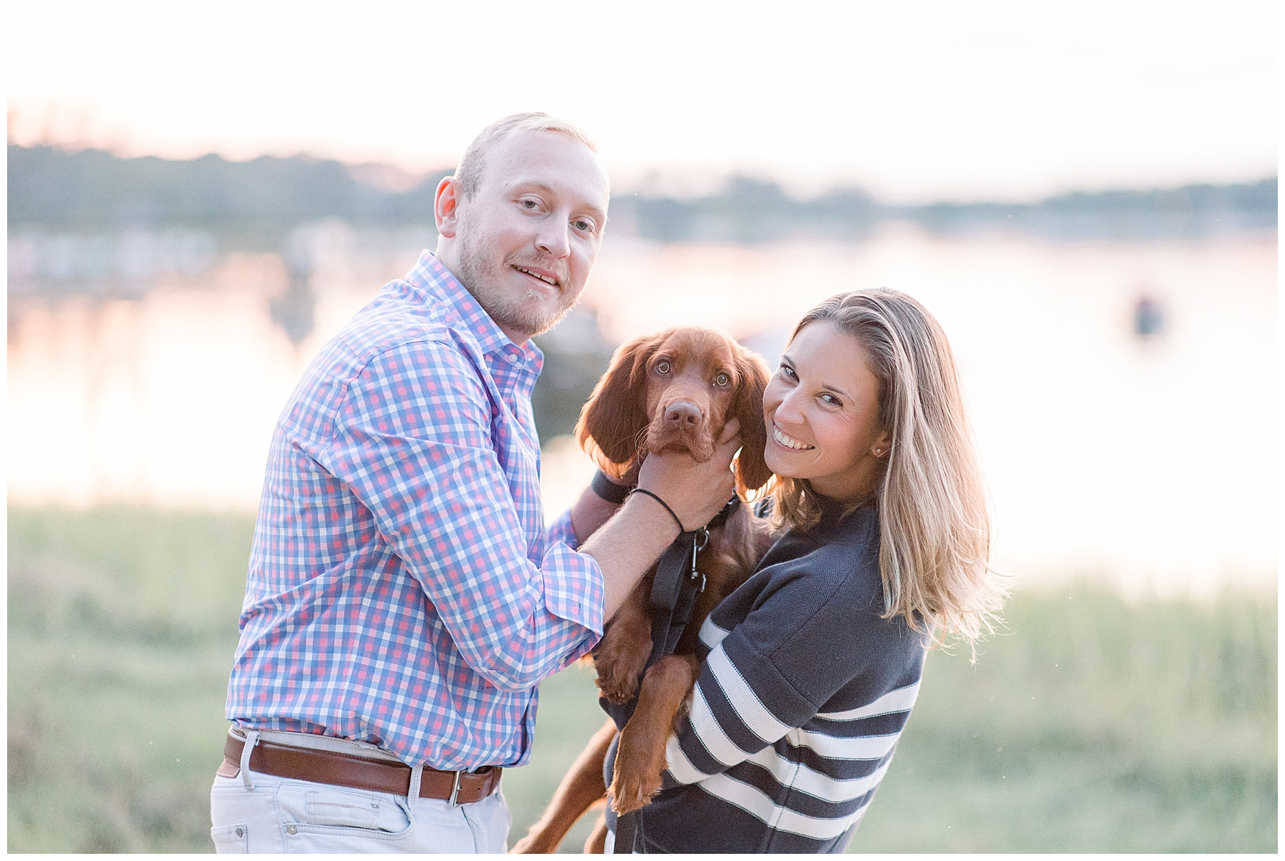 engaged couple in blue hold their adorable brown dog