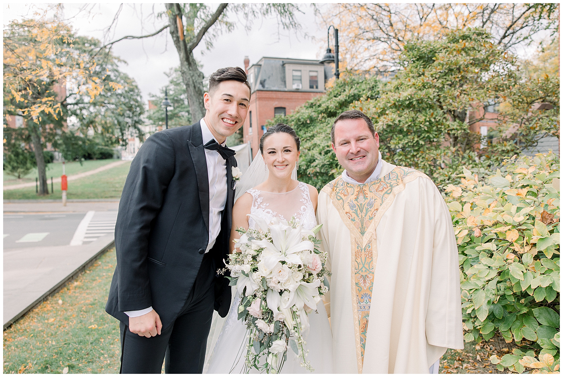 married couple stand with priest after wedding ceremony