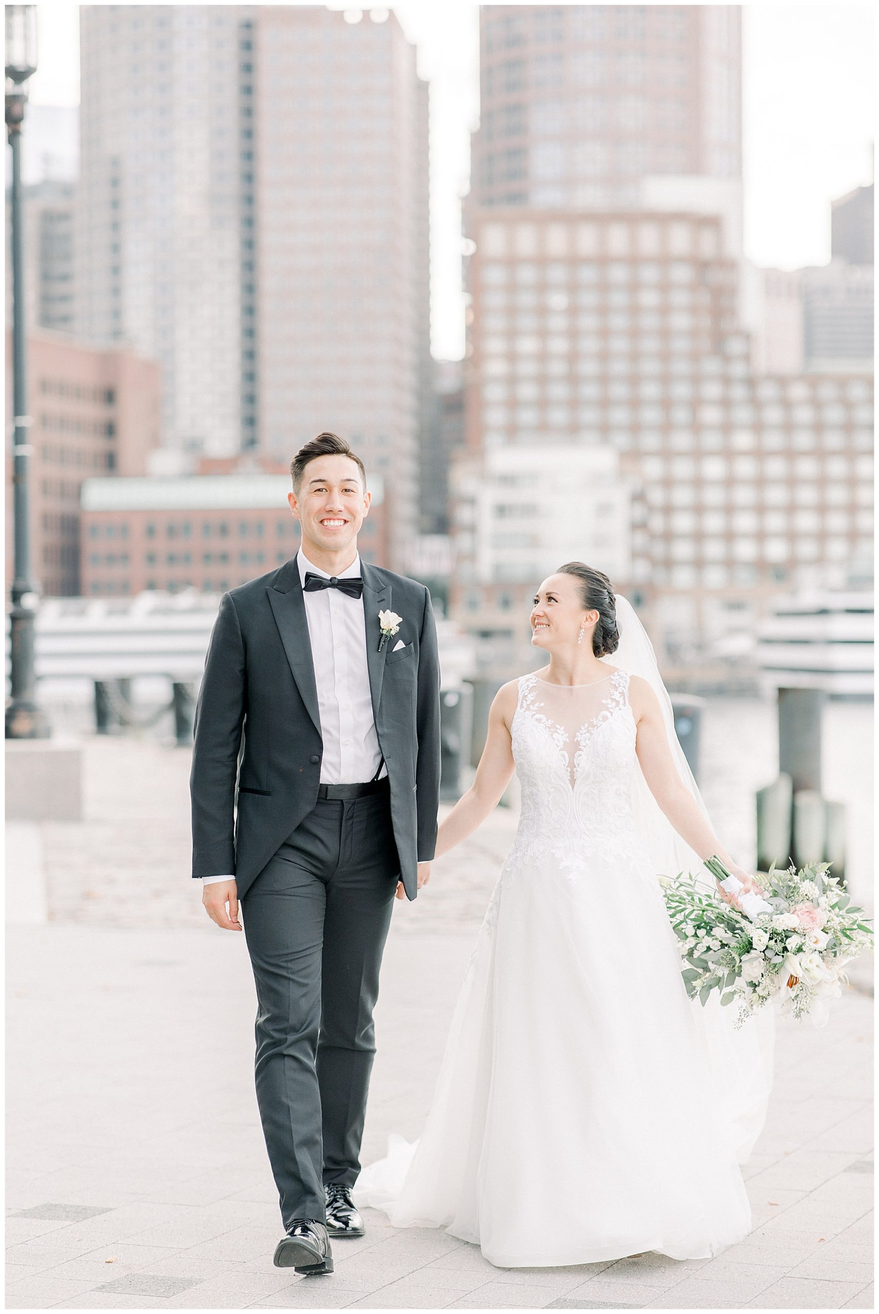 couple walking together with the boston skyline in the background