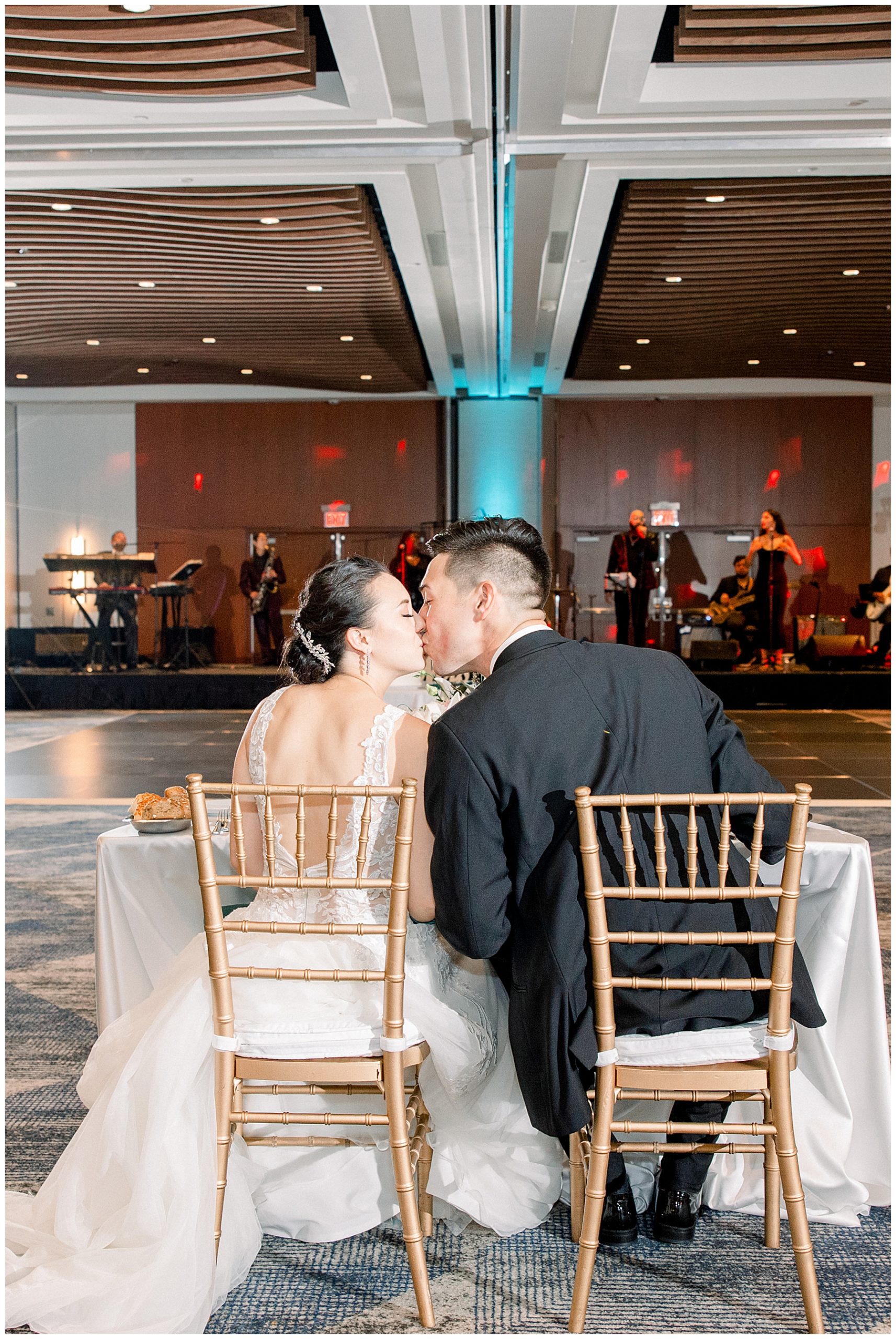 husband and wife kiss at their head table at wedding reception Boston Marriott Long Wharf Wedding