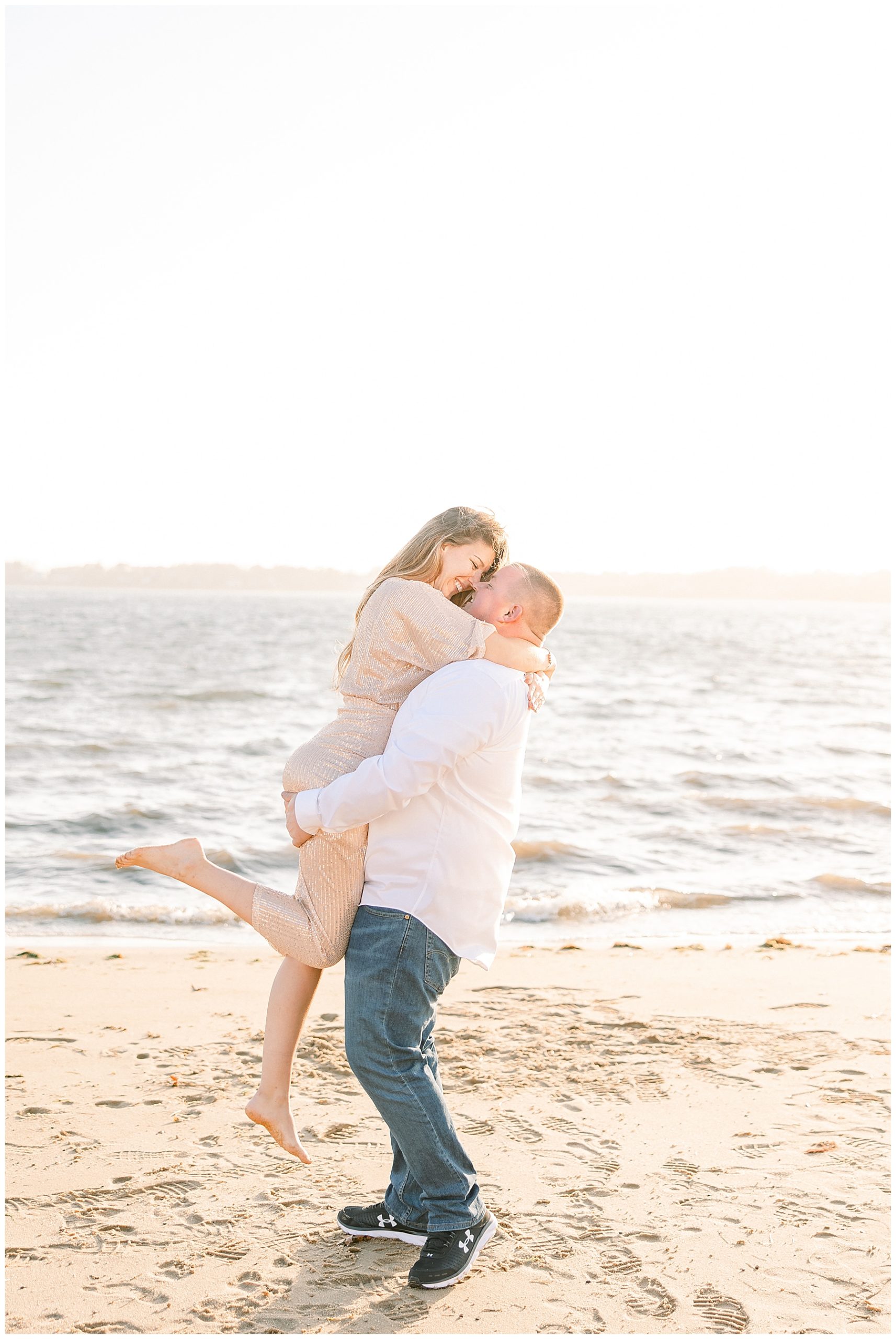 man lifts up his fiance during engagement session