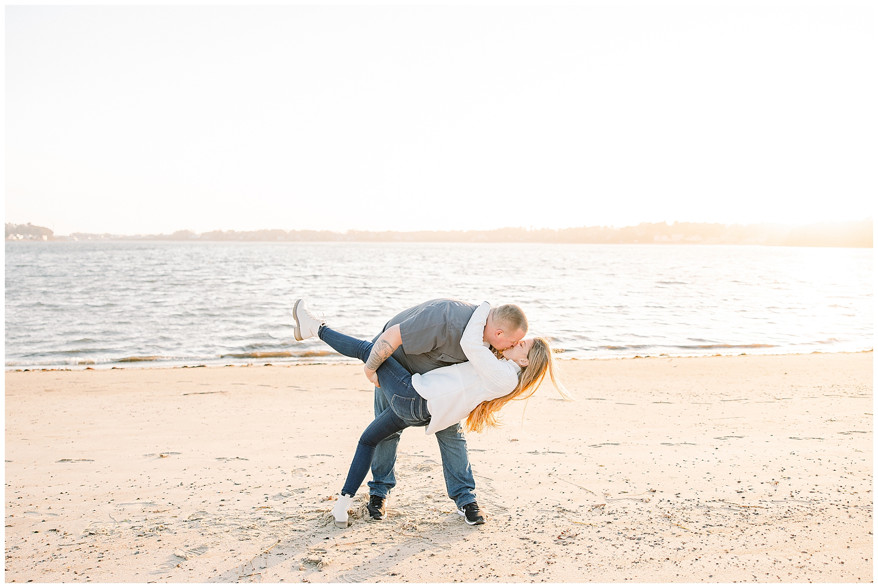 man dips his fiance on the beach at cape cod MA