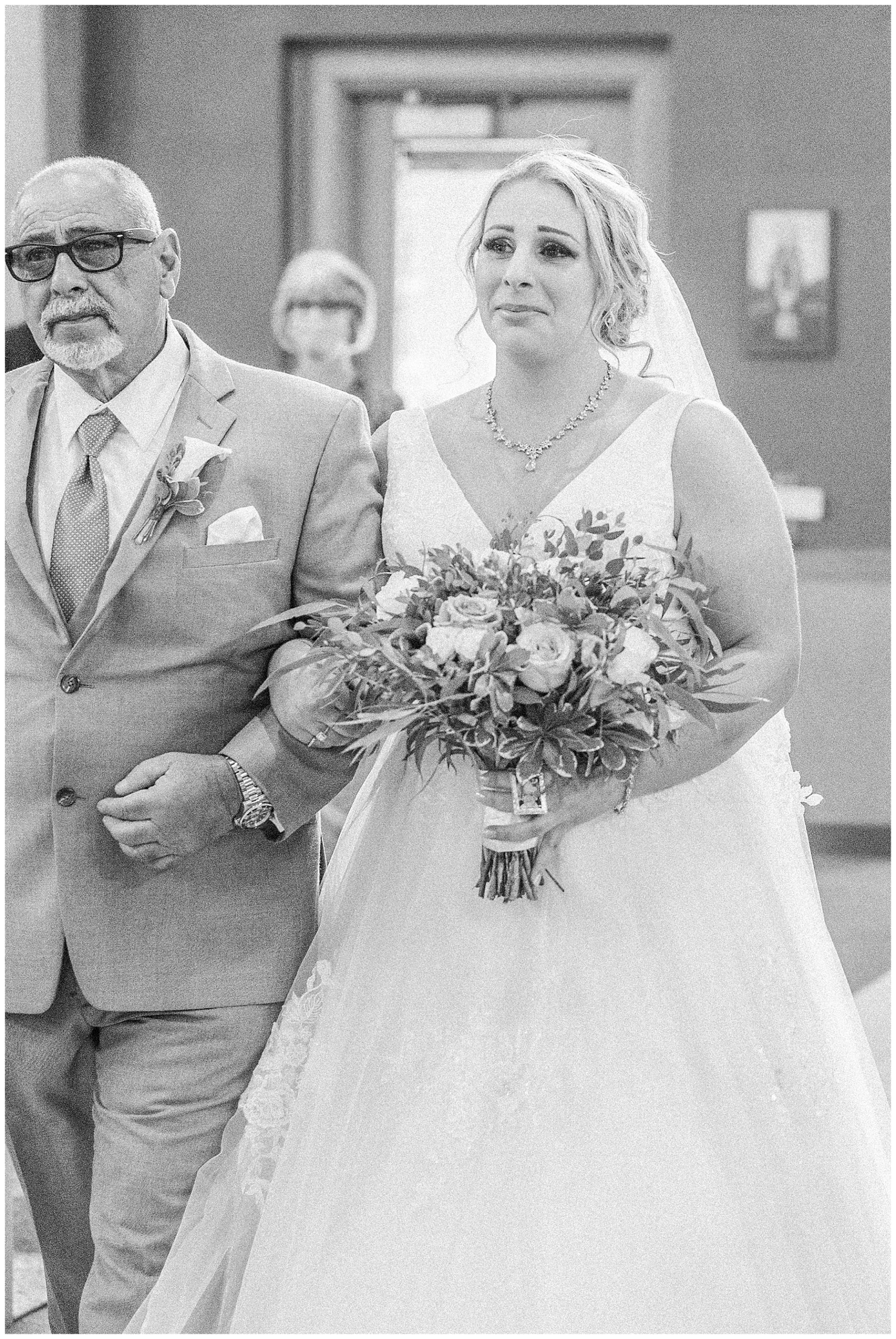 bride walks down the aisle with dad at wedding ceremony