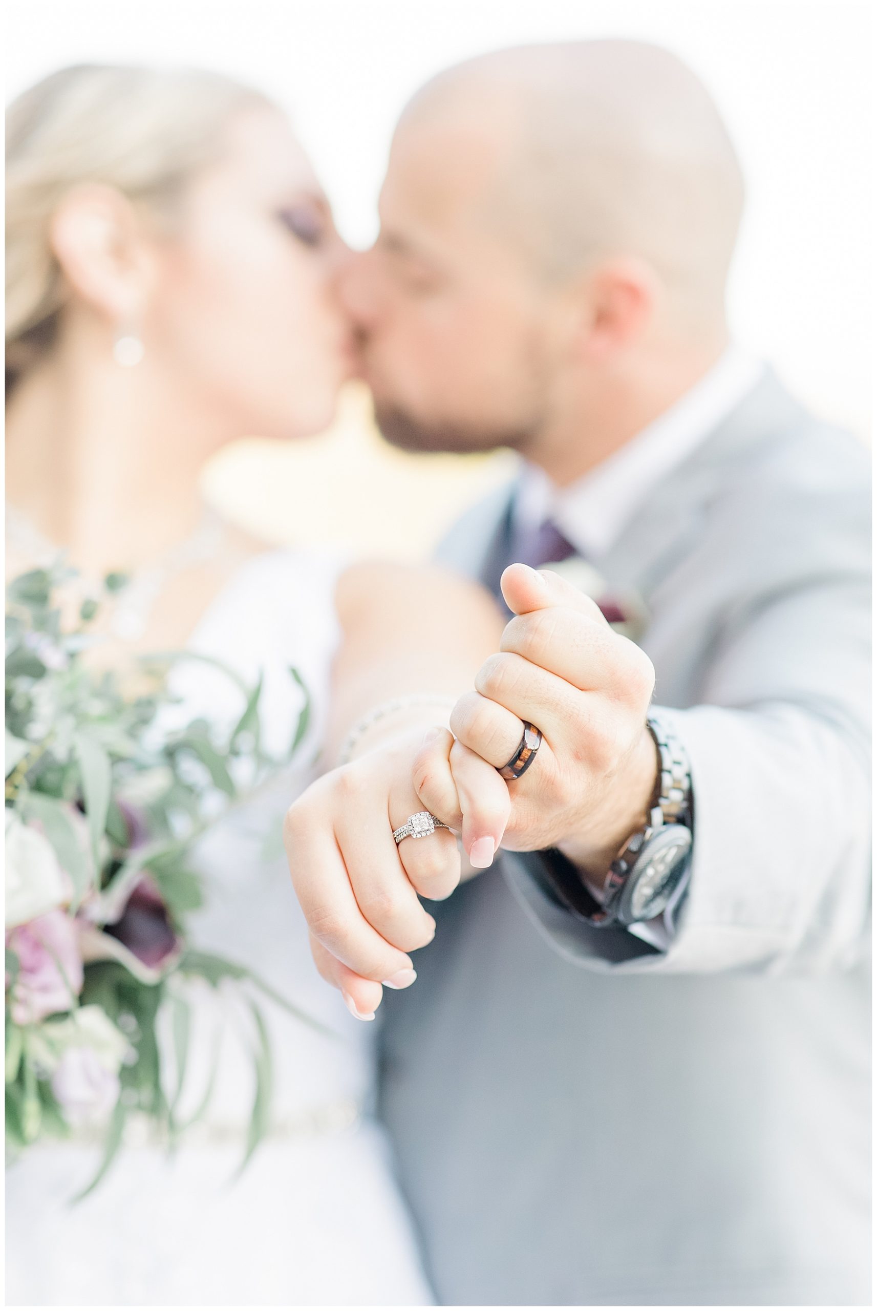 newlyweds kiss and show off wedding rings