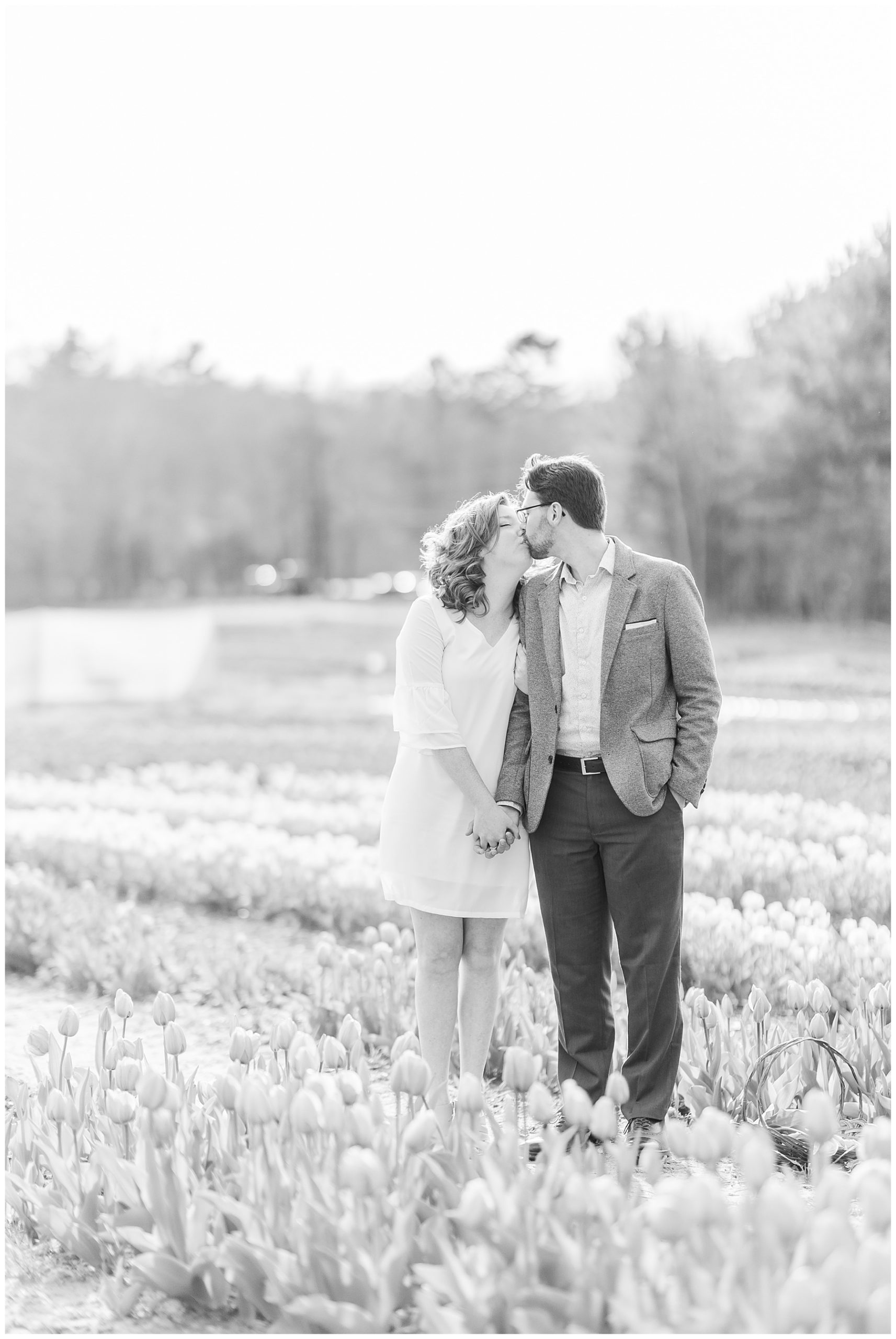 newly engaged couple walking through field of tulips