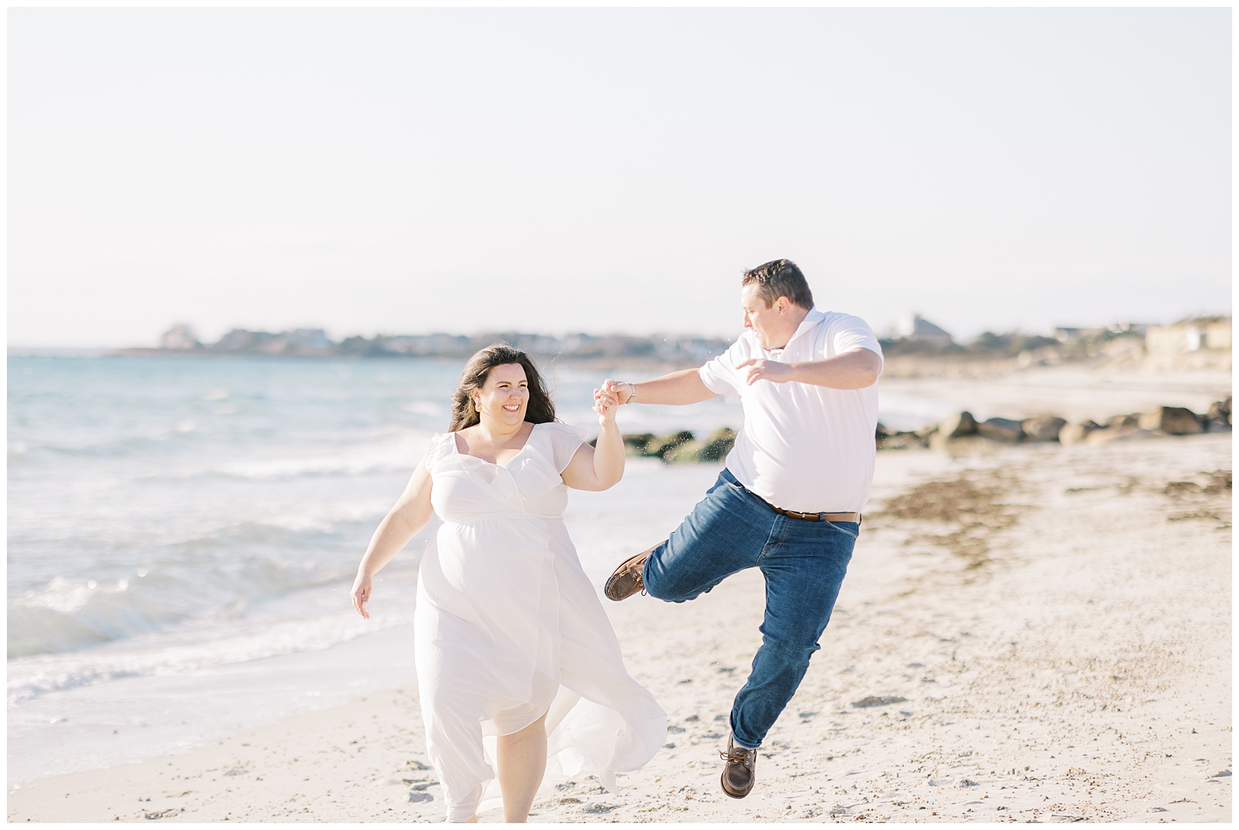 candid photo of couple on the beach having fun during engagement photos
