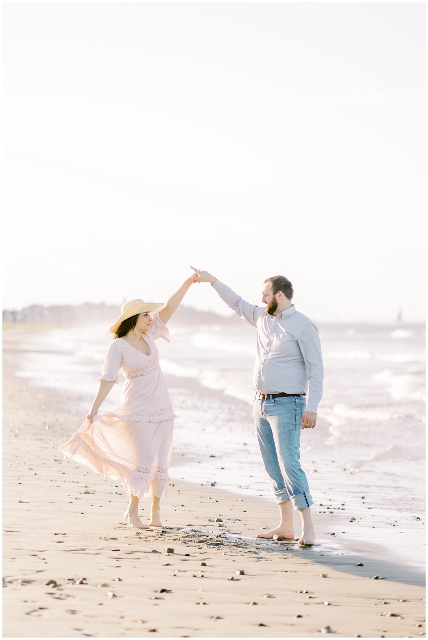 couple dances together on the beach for romantic engagement portraits 