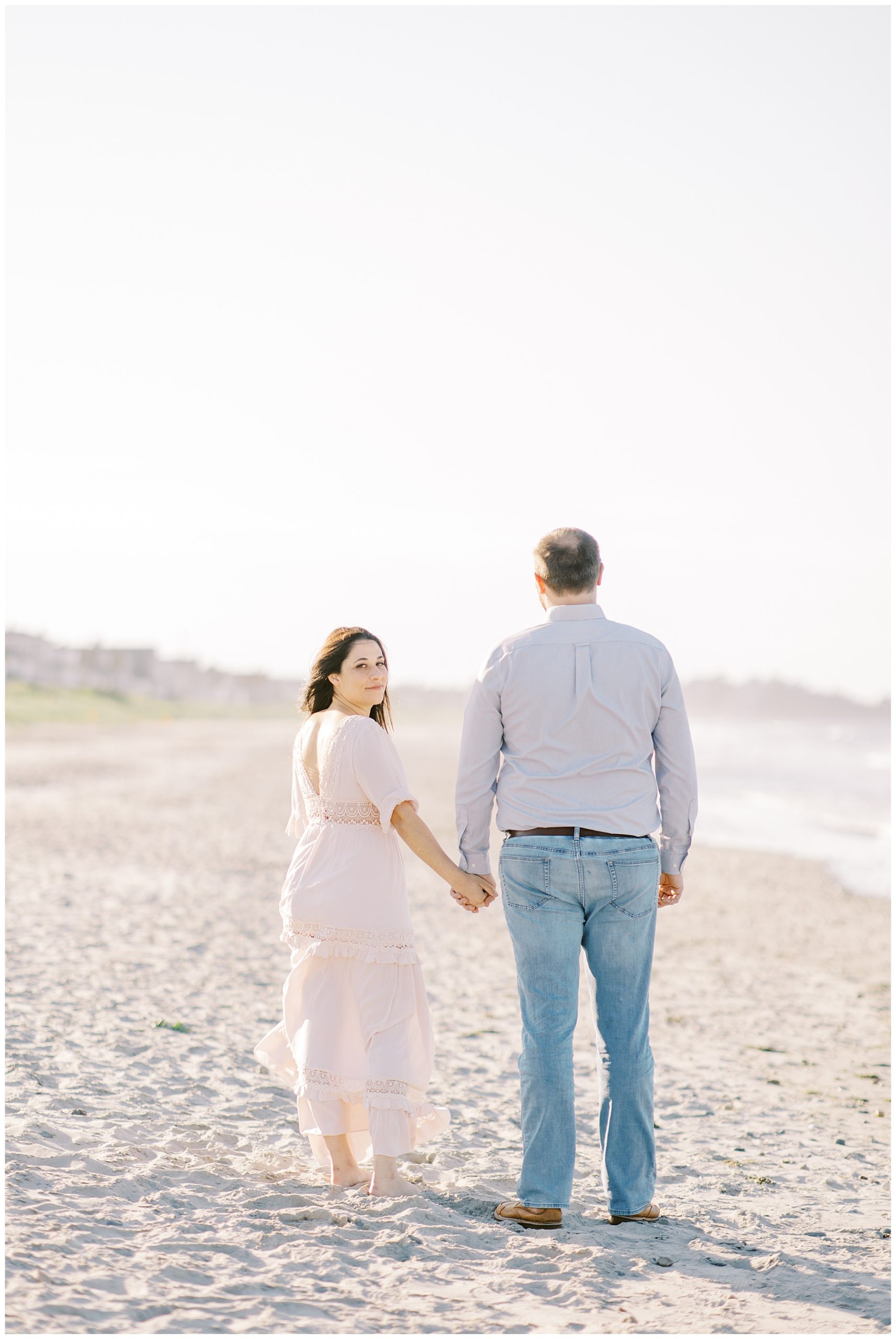 couple walk together holding hands at Nantasket Beach 