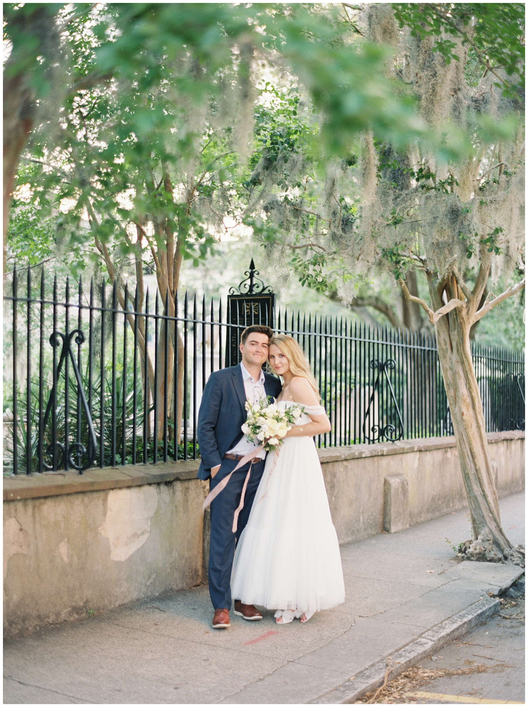 bride and groom during honeymoon session by downtown Charleston Session