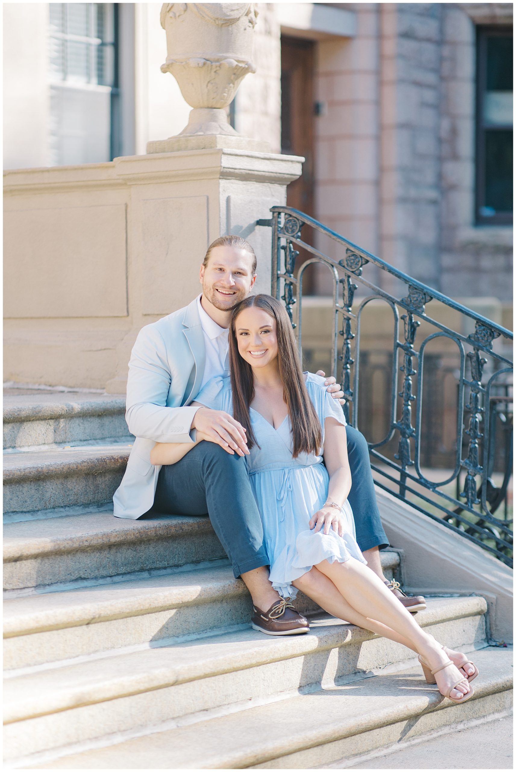 couple sit on stairs of old building in downtown Boston