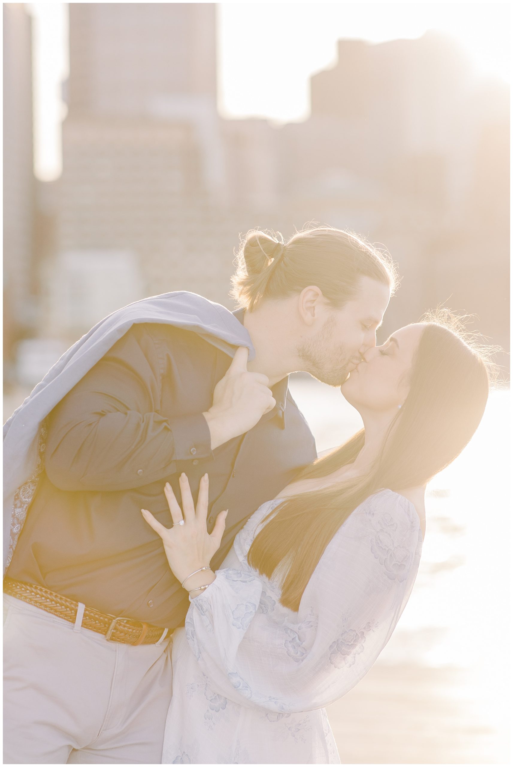 golden glow of the sun surrounds couple as they kiss