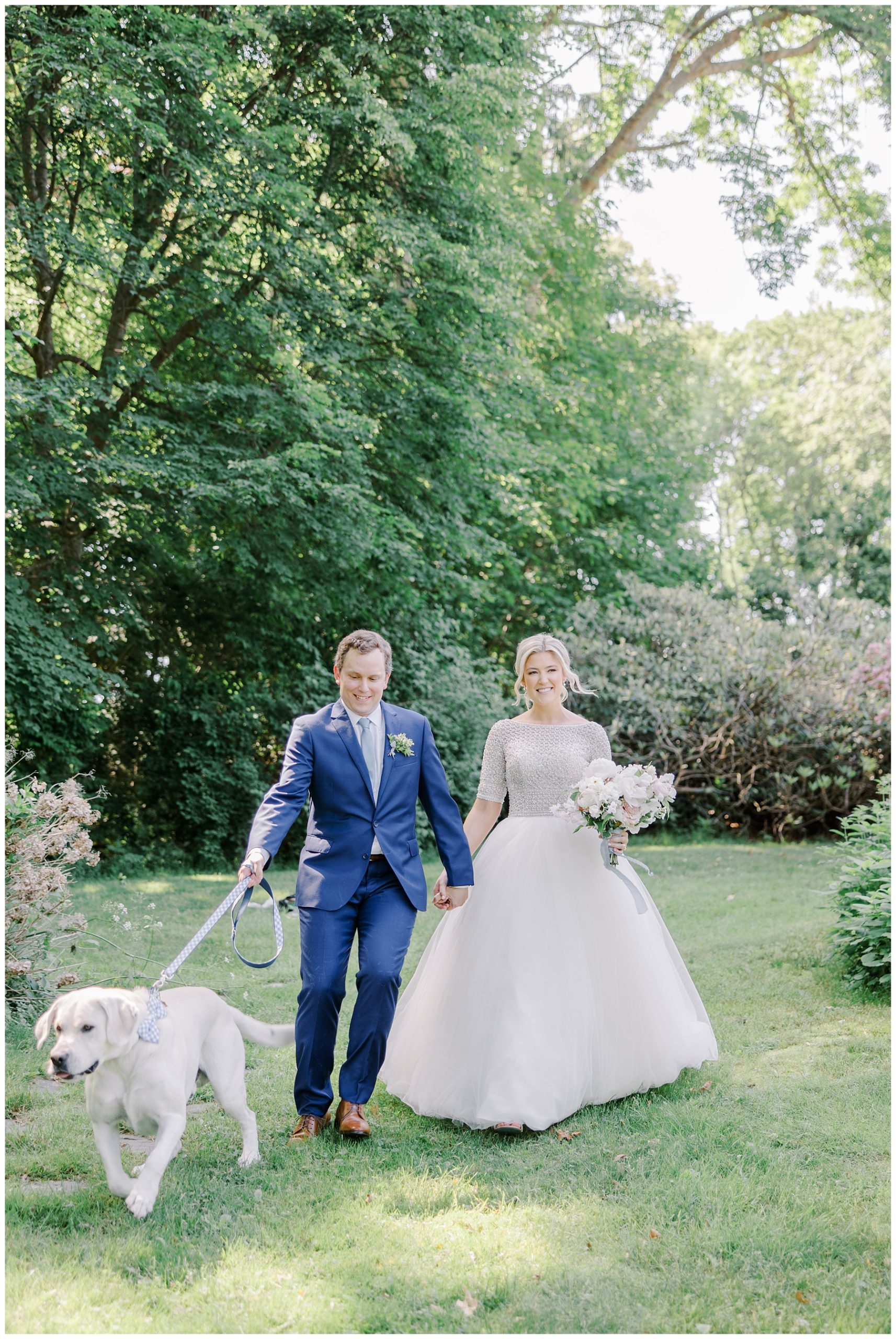 bride and groom walk with their dog before wedding ceremony 