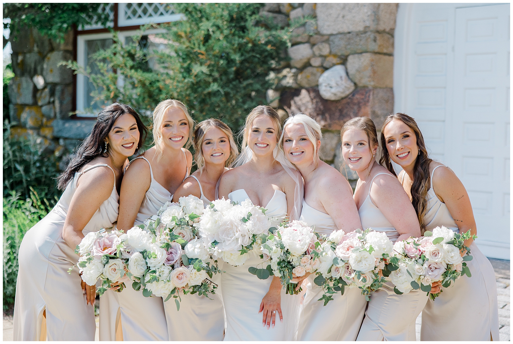 bride and bridesmaids together holding flower bouquets 
