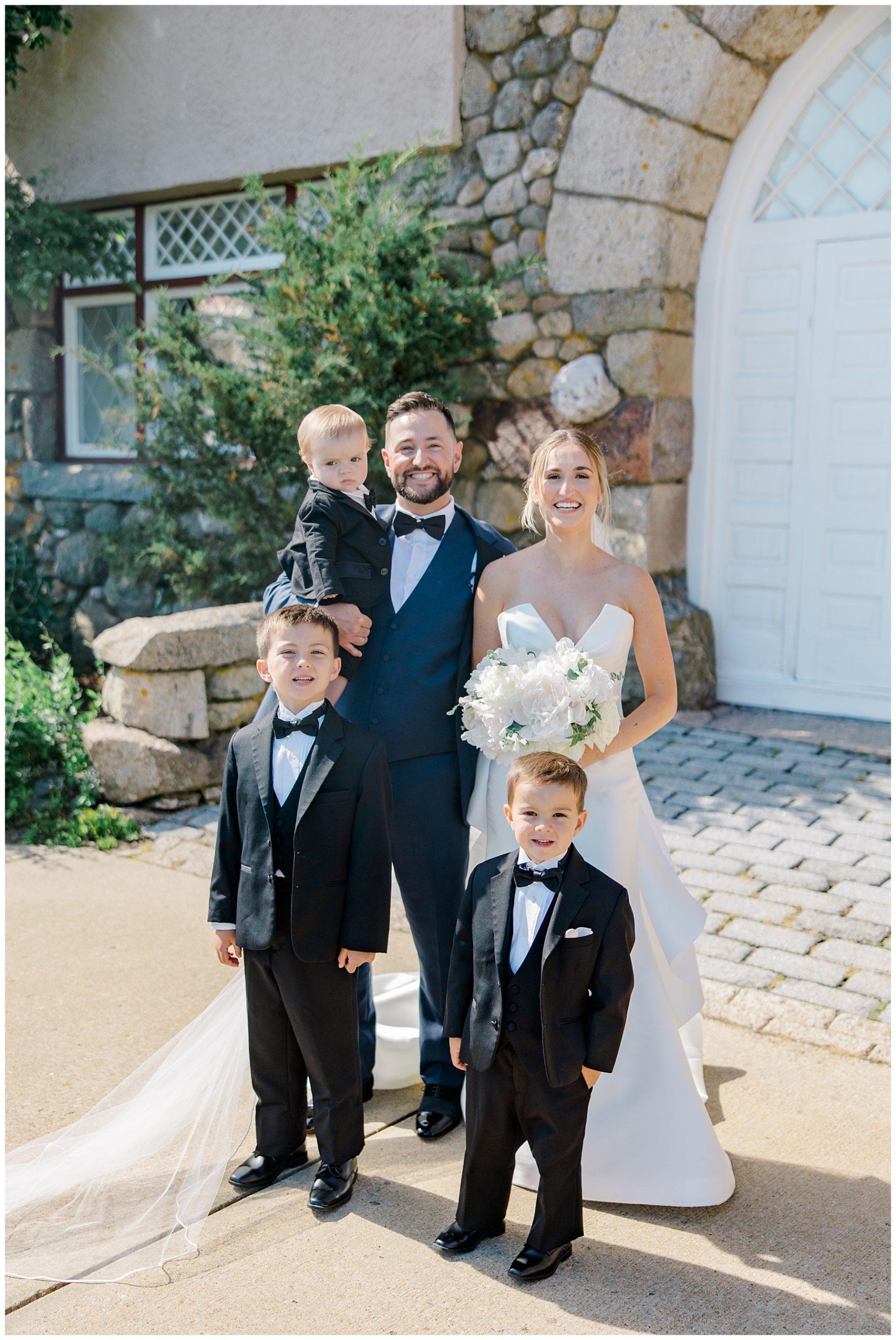 bride and groom with two little boys in wedding 