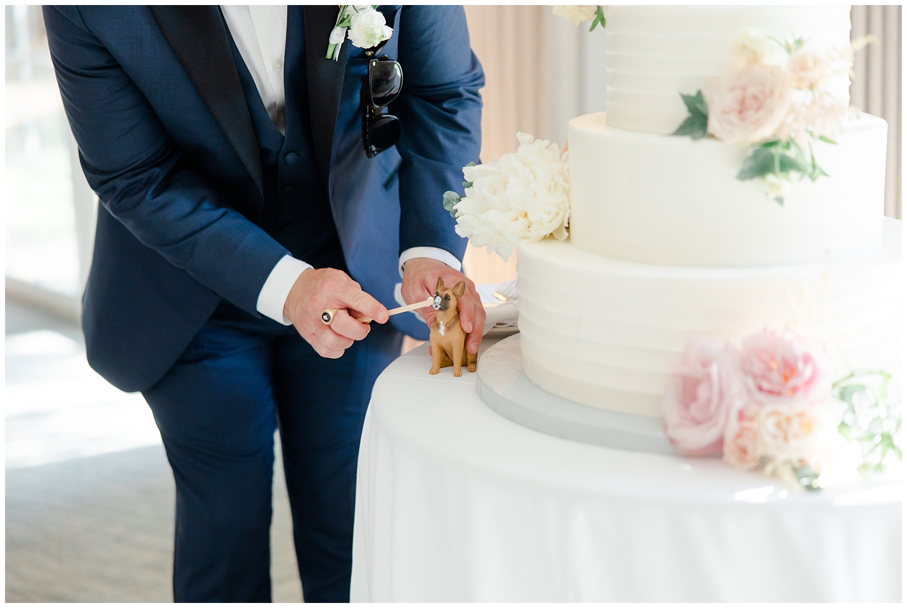 groom places dog figurine on cake 