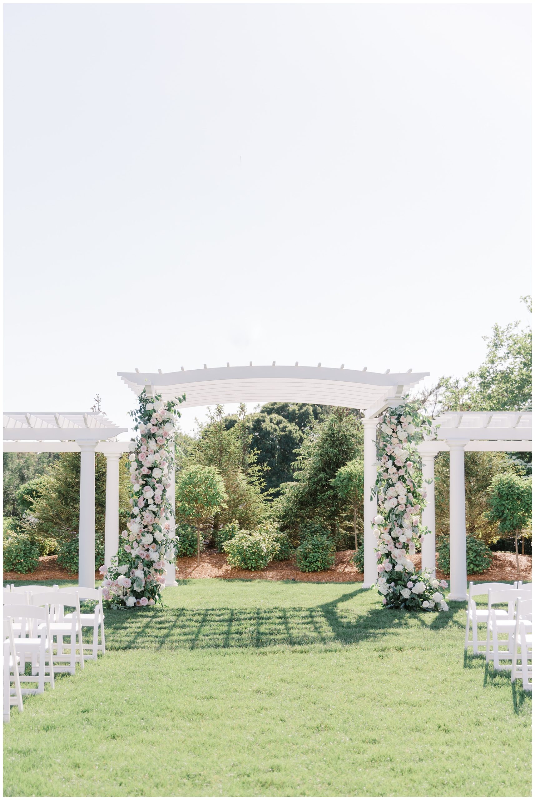 white wedding arch decorated with flowers for wedding ceremony 