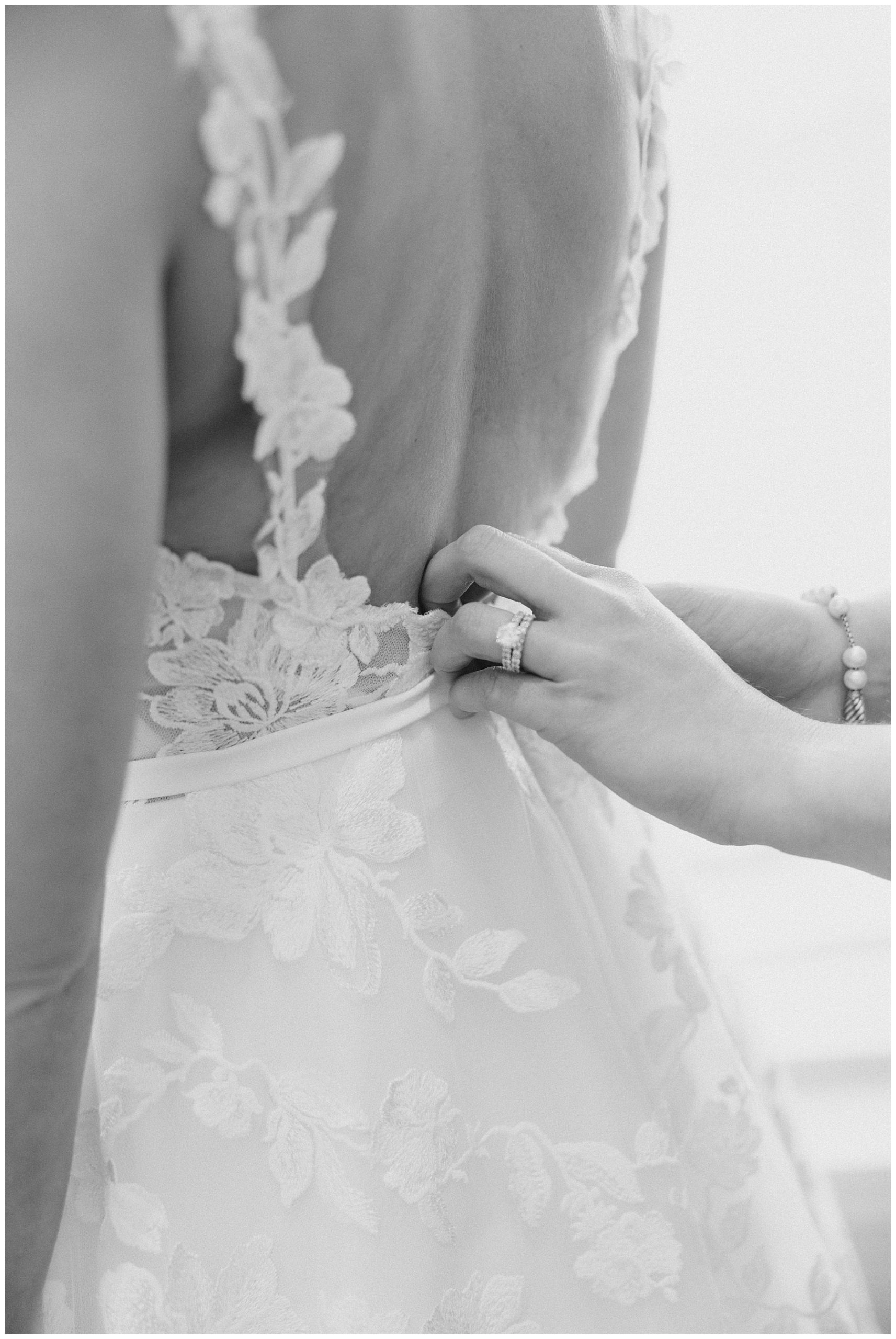 bride getting her dress buttoned up