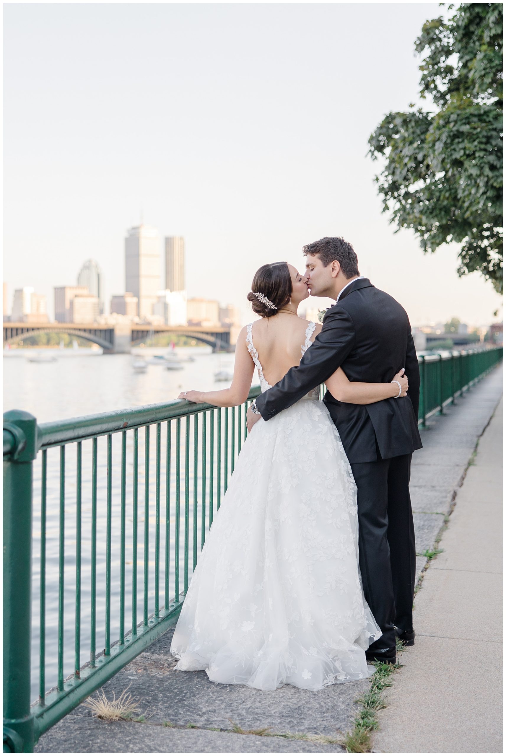 couple kiss while enjoying the Boston skyline at Glamorous Royal Sonesta Wedding 