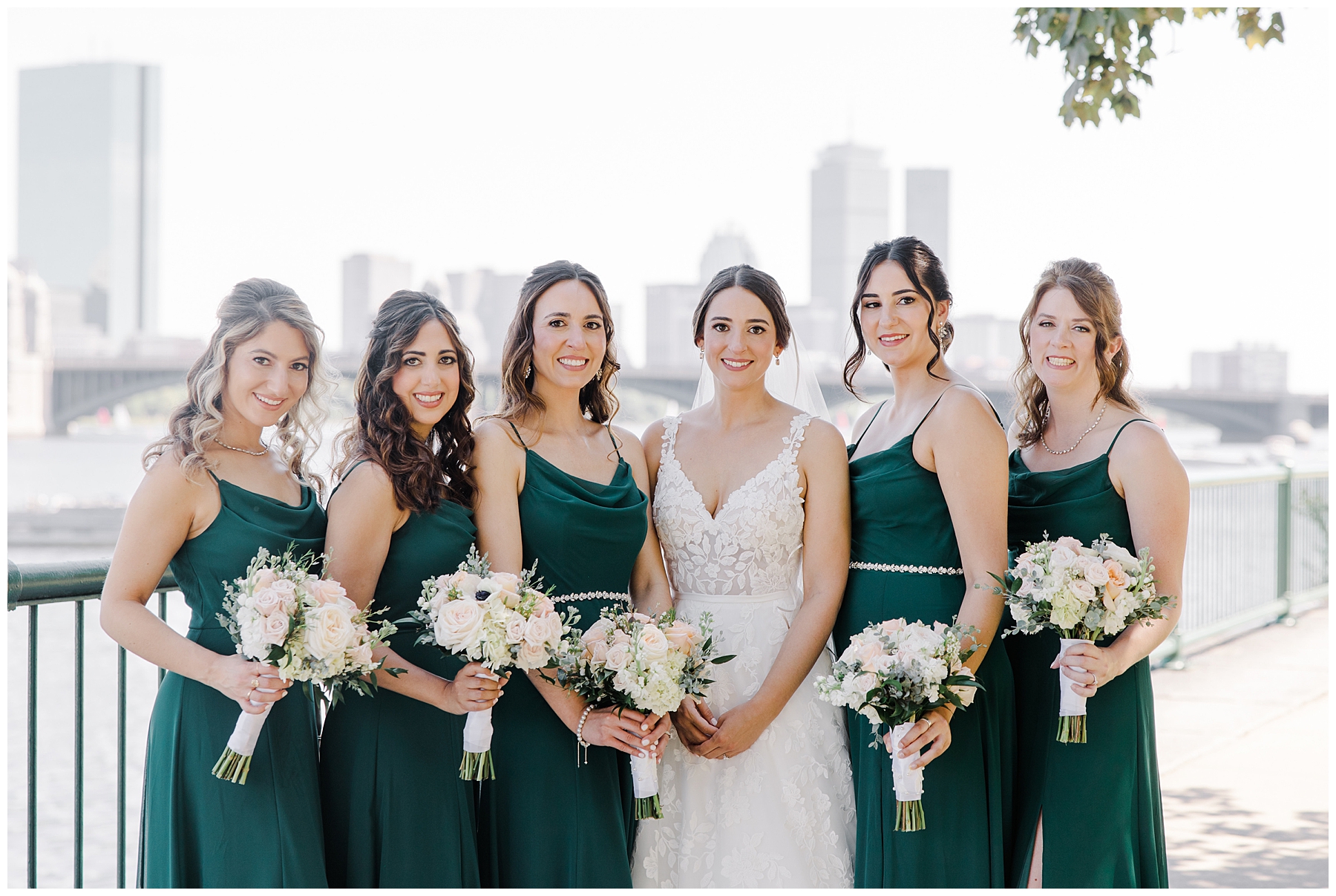 bride and bridesmaids in deep green dresses holding bouquet