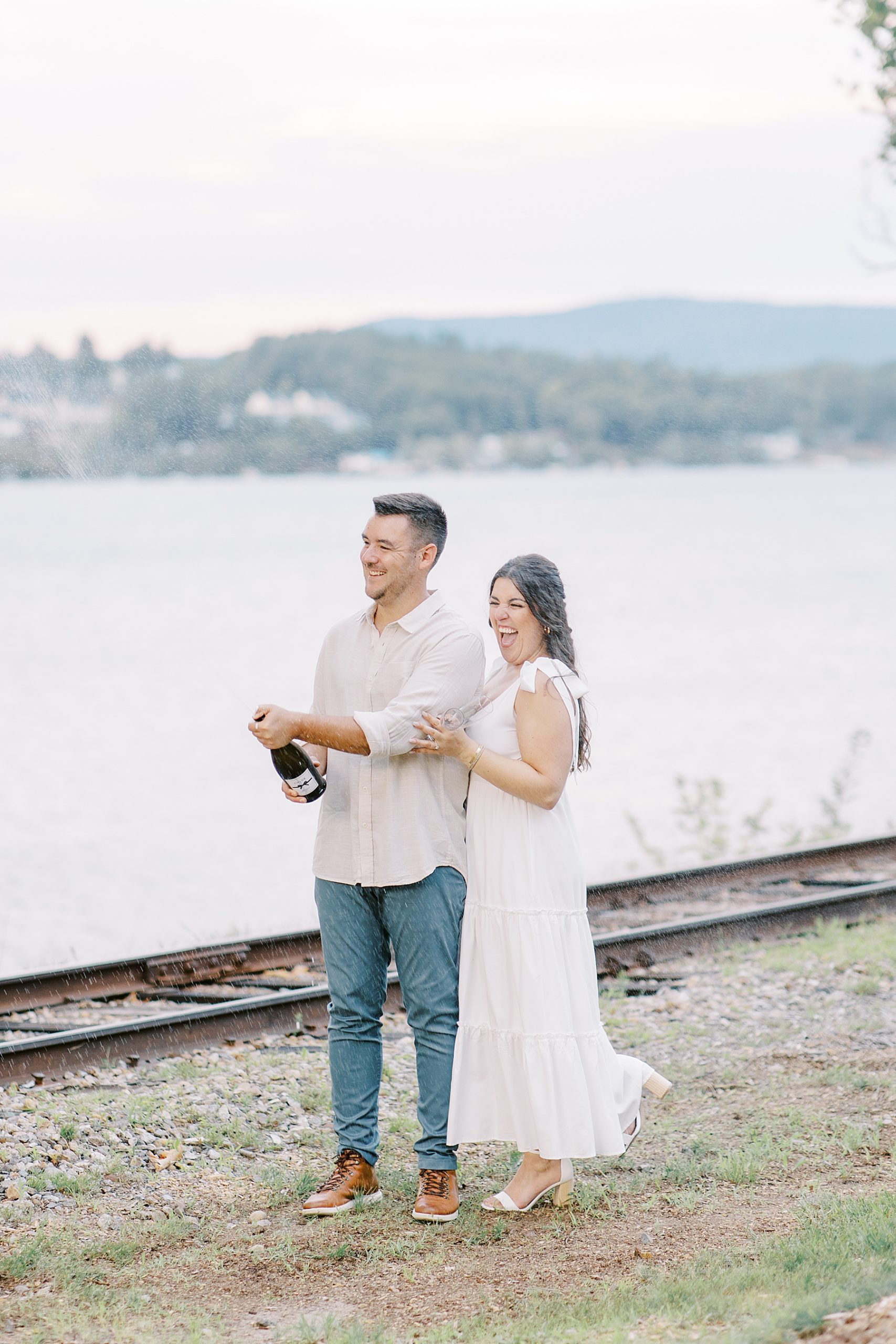 engaged couple pop champagne to celebrate during engagement session