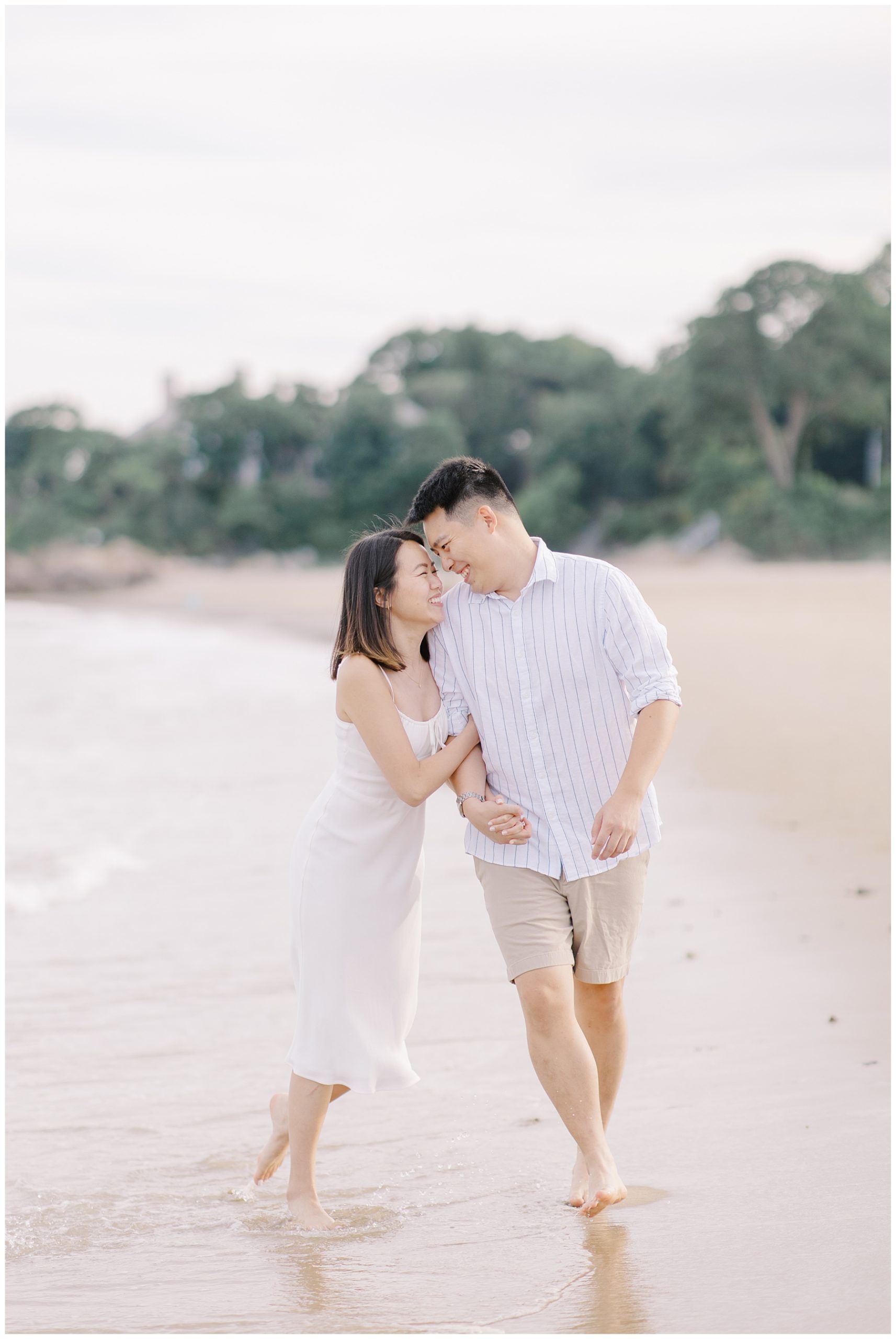 joyful couple laugh together during Romantic Beach Engagement Session in Beverly, MA